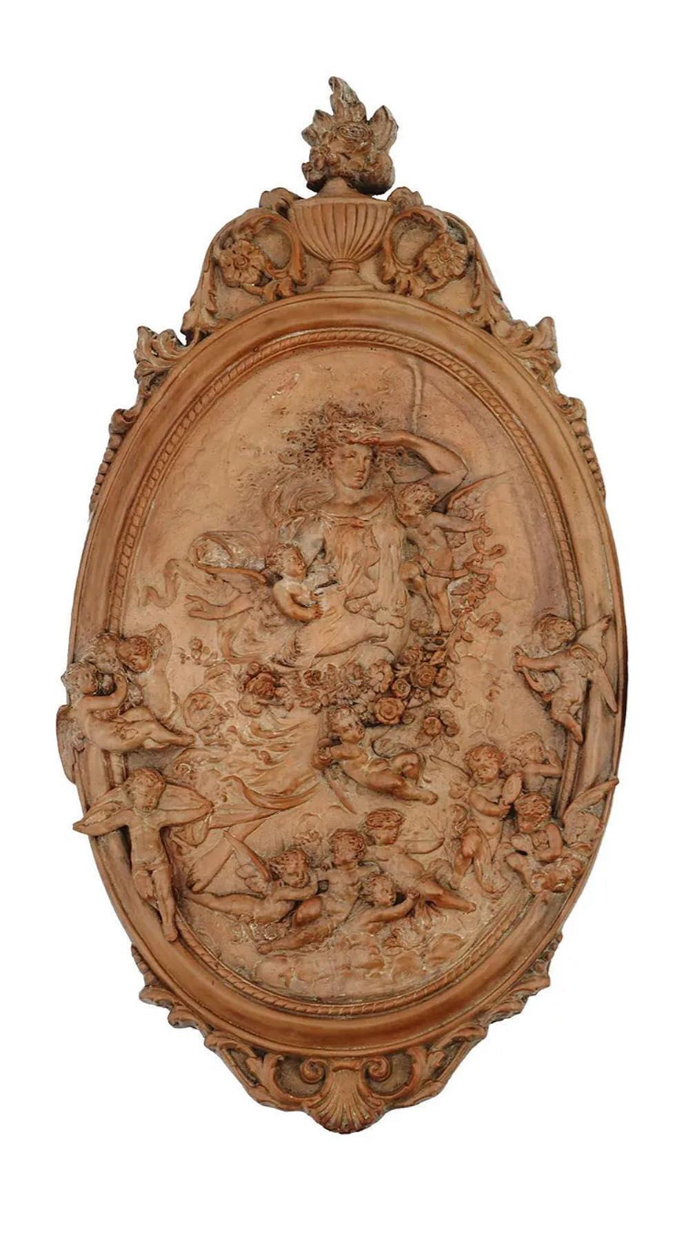 Matched pair of bas-relief plaques in the neoclassical style, molded from terracotta or similar composition, depicting a goddes s among the clouds, surrounded by angels in flight.  
