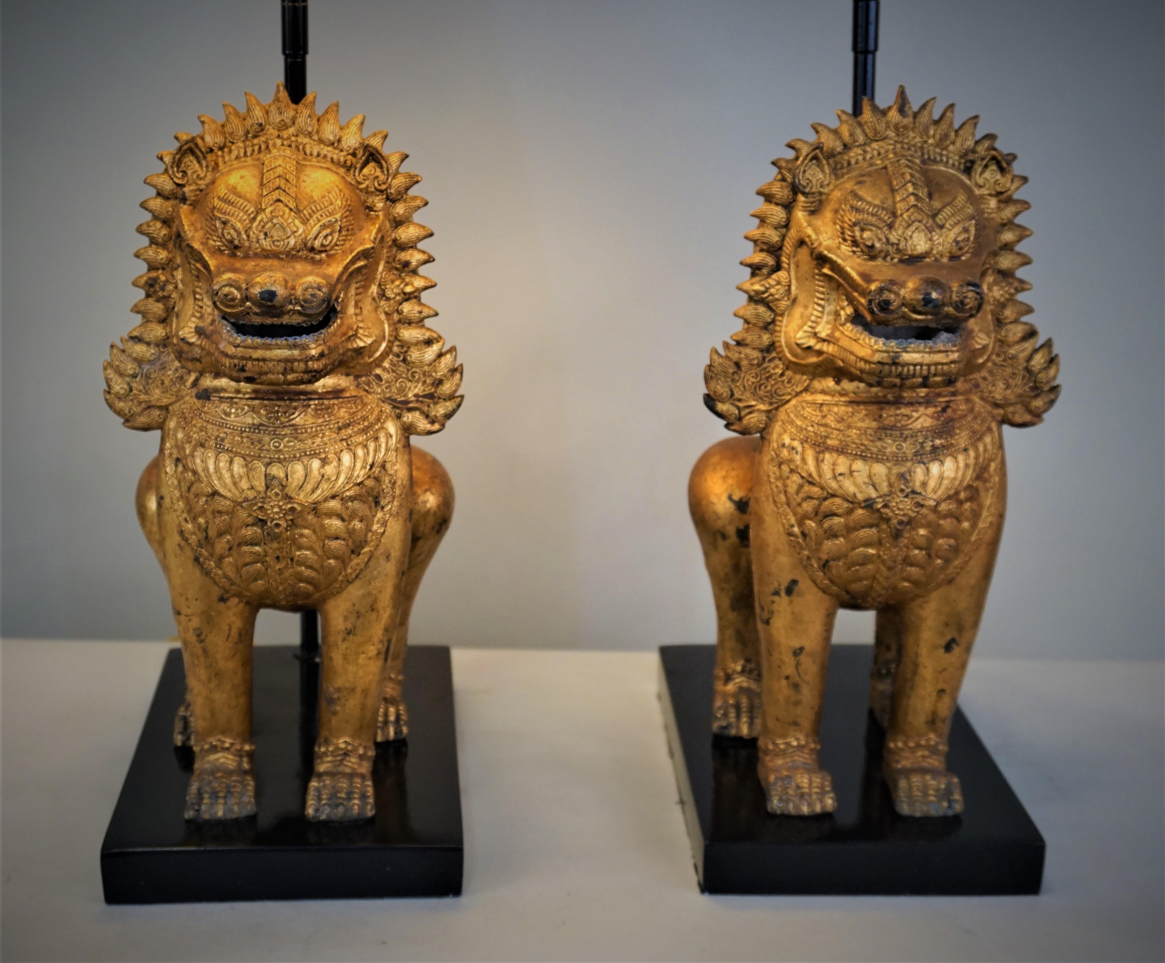 Custom made pair of gilt bronze foo dogs to table lamp and fitted with square black lampshades.