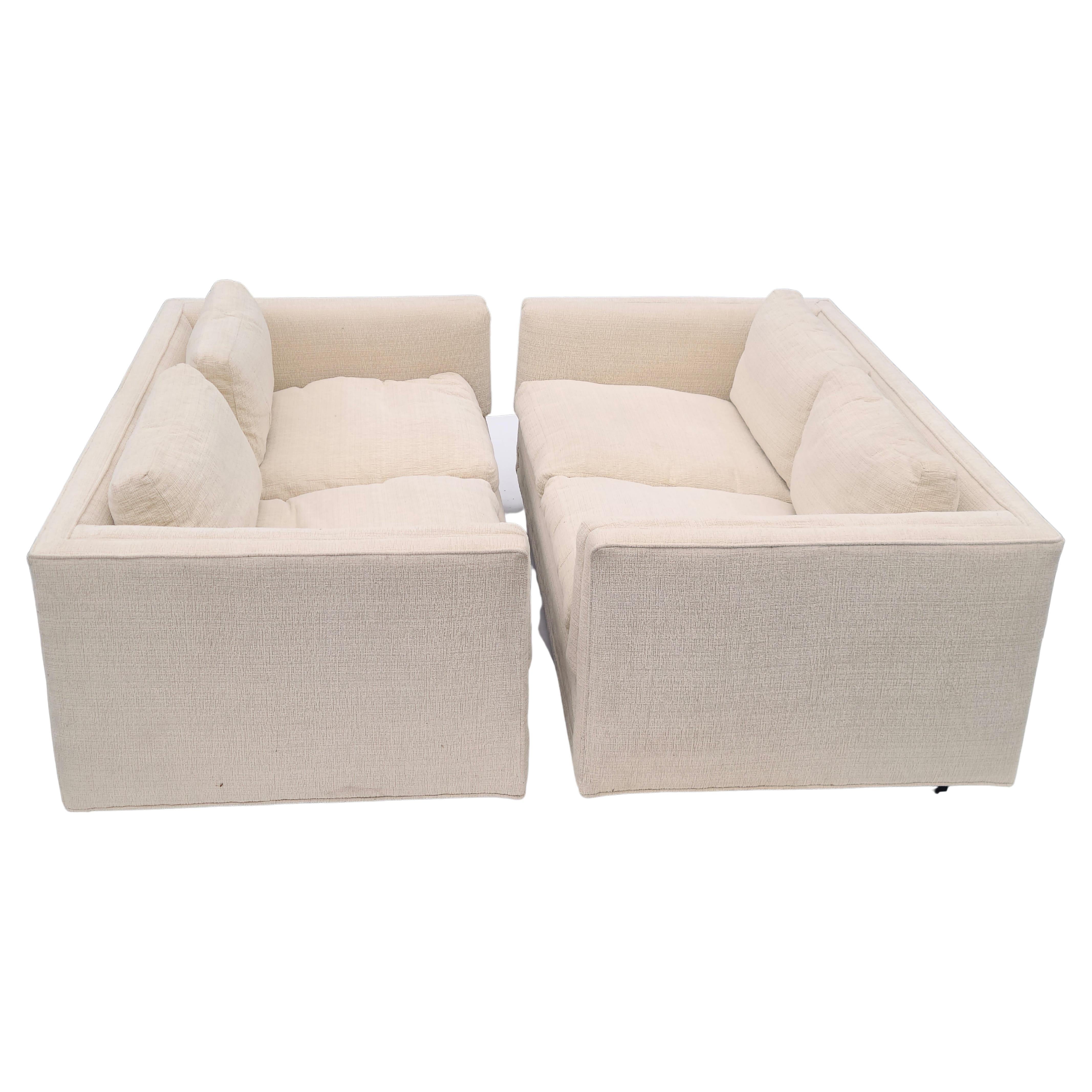 Please feel free to reach out for efficient shipping to your location.

Pair Tuxedo Loveseats.
Recent reupholstery.
Original label missing.
Clean off-white soft textured fabric.
Black lacquer plinth bases.
Matching design by Milo Baughman for Thayer