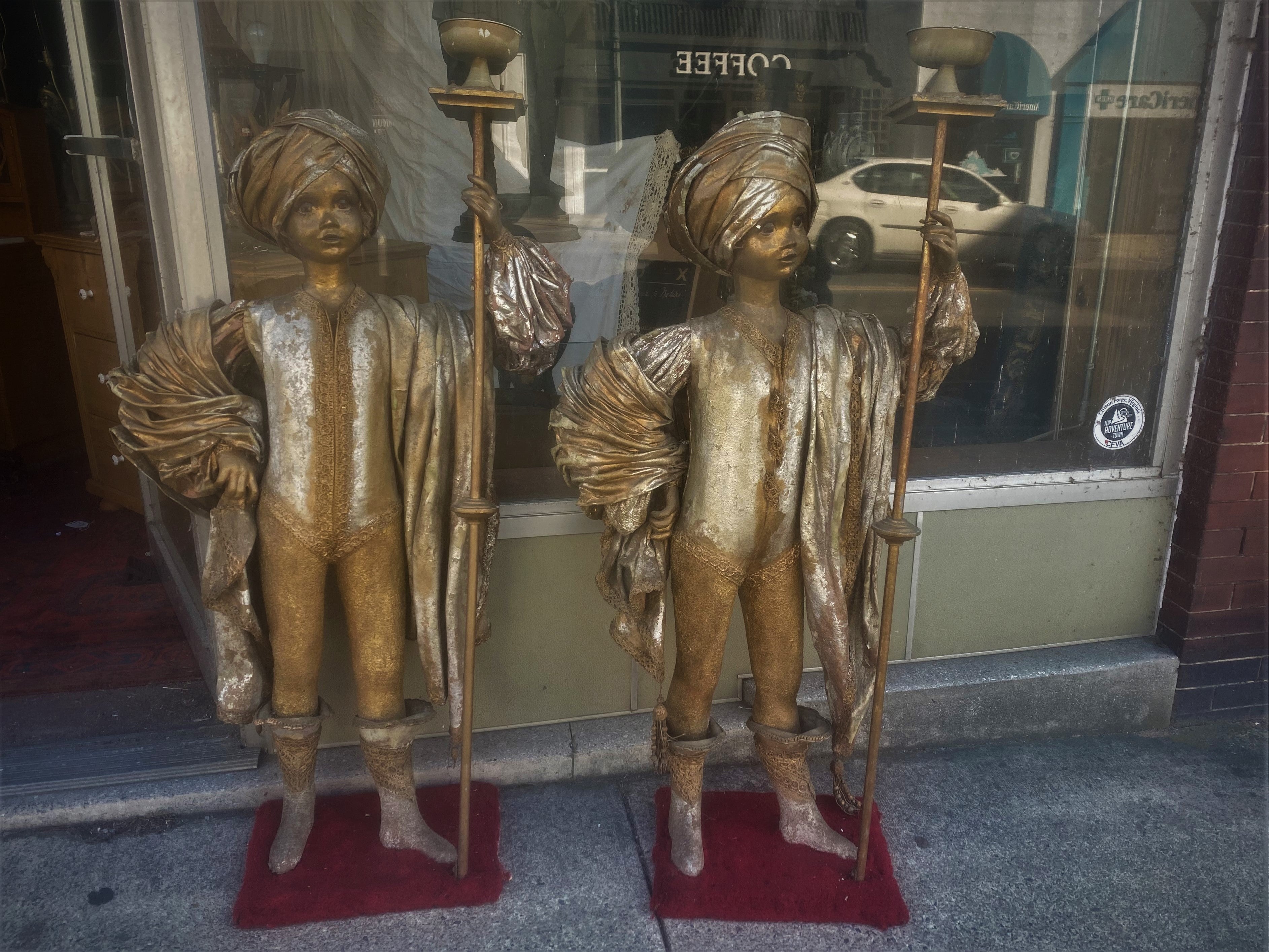 Se trata de un adorable par de figuras de tamaño infantil con trajes ornamentados de estilo de Oriente Medio que incluyen antorchas, turbantes, botas y un chal. No sé de dónde proceden, pero parece que formaban parte de un decorado o expositor y