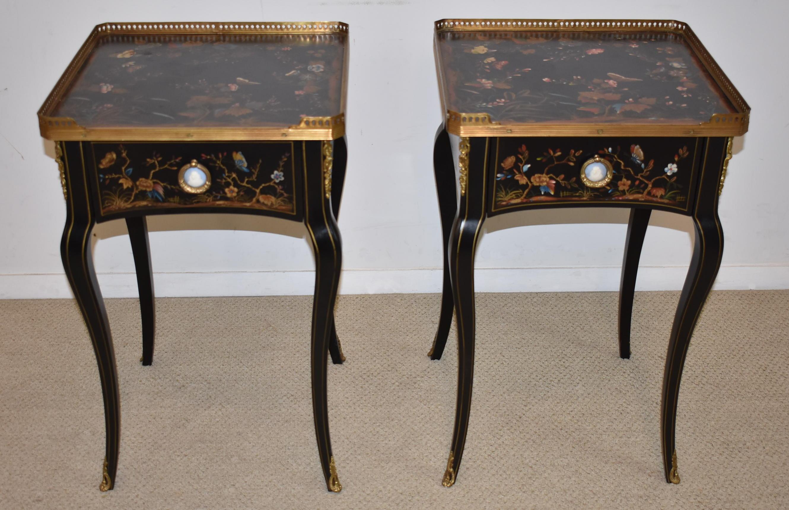 Pair of Theodore Alexander black lacquered side tables. French Empire style with hand painted Asian themed designs of flowers and butterflies. Brass gallery and mounts. Wedgwood medallion with heavy cast wreath form loop handle.