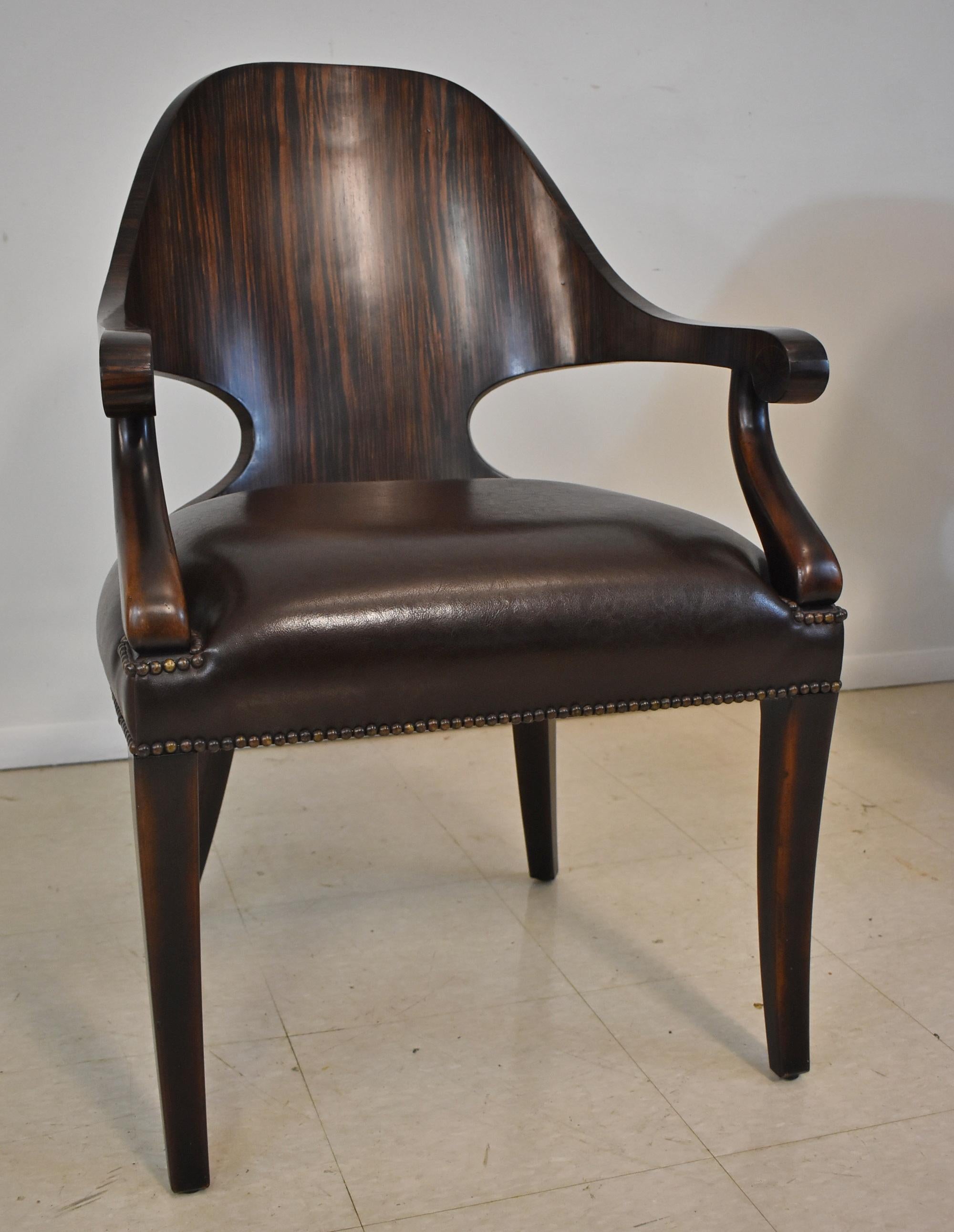 Pair of Theodore Alexander rosewood and leather armchairs. Beautiful rosewood finish on the curved back and scroll arms. Leather seat has brass nail heads surrounding the bottom edge and the base of the arm. Excellent condition. 24
