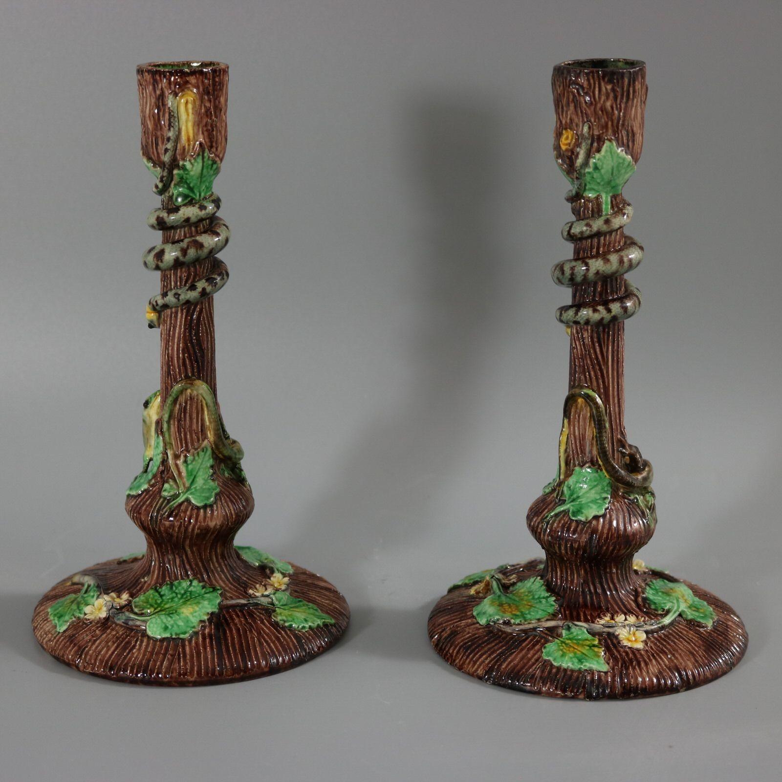 Pair of Thomas Sergent French Palissy Majolica candlesticks which feature blossom and leaves around the base. A lizard peering up at a snake to the stem. Colouration: brown, green, grey, are predominant. The piece bears maker's marks for the Thomas