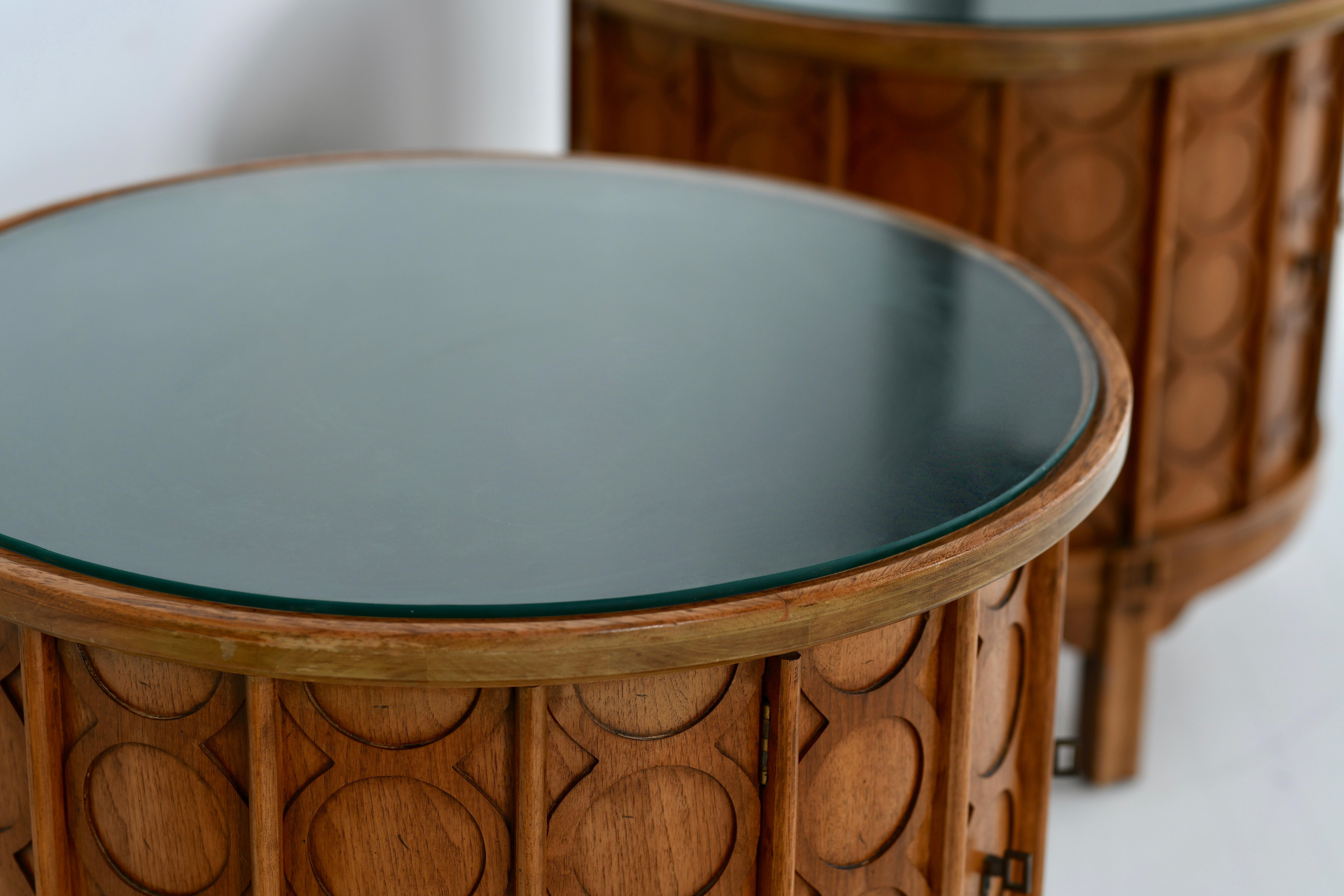 Thomasville drum side tables with good patination to the walnut veneer. It has a ebonized top with a glass insert thats removable. It has two doors with original bronzed hard ware. A piece of fine American craftsmanship from the 1960s.