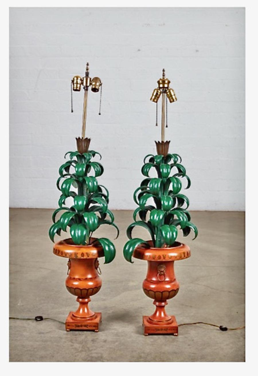 This is a wonderful pair of tole mid-century palm topiary lamps featuring a regency-style lion head urn and vibrant green palm fronds. The height of the bases is 33
