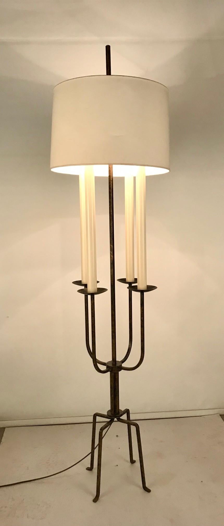 Elegant Vintage pair of floor lamps, designed by Tommi Parzinger, American, circa 1950s. They retains their original lightly gilded over black iron patinated painted finish with original patina. They have been rewired to UL standards. A rare true