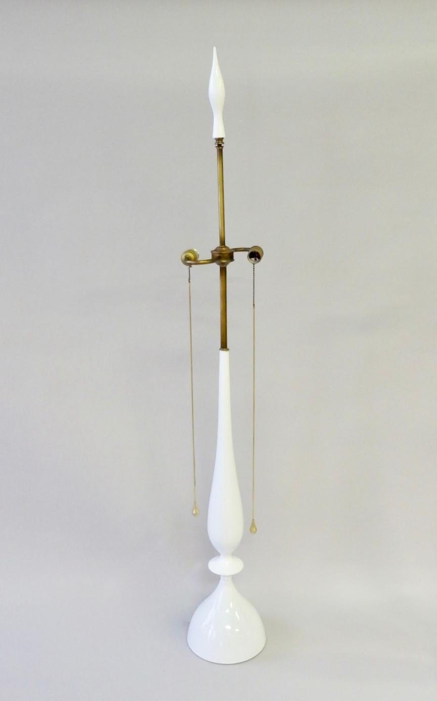 Tall white lacquered walnut base lamps with brass trim and polished brass teardrop on/ off switch pulls. Original white lacquer finials are included. Stamped Rembrandt on underside. Overall height is 50 plus 6 for the finial. Shipping may be