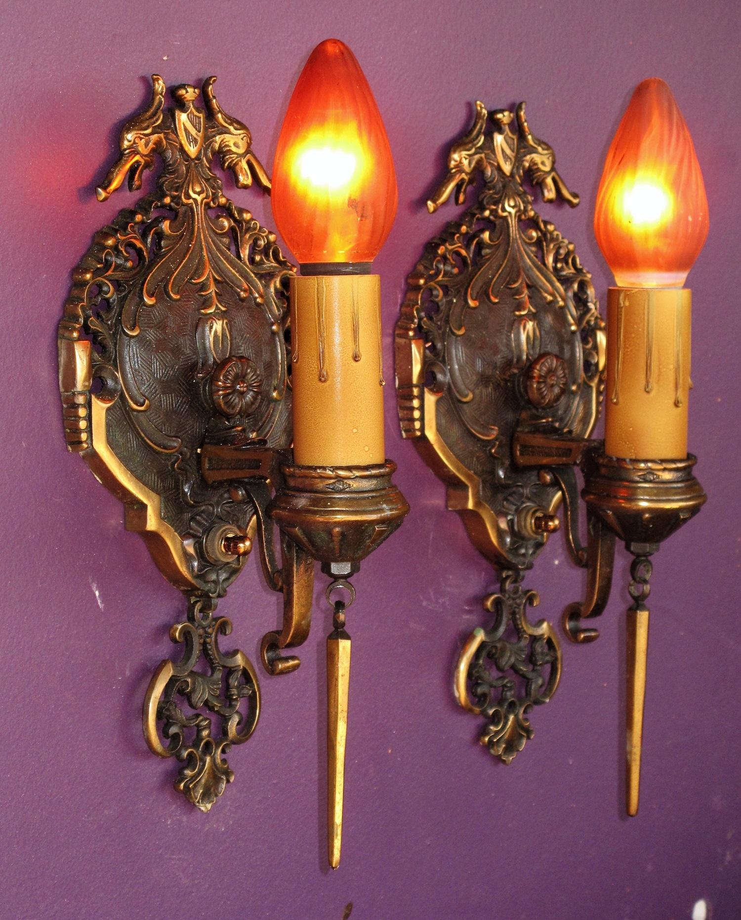 Wonderfully executed solid bronze sconces by Mid-West Chandelier Co., shown in their 1928 catalog. These outstanding sconces retain their original finish and patina. With detailed dragon heads protecting their environment down to the icicle finials