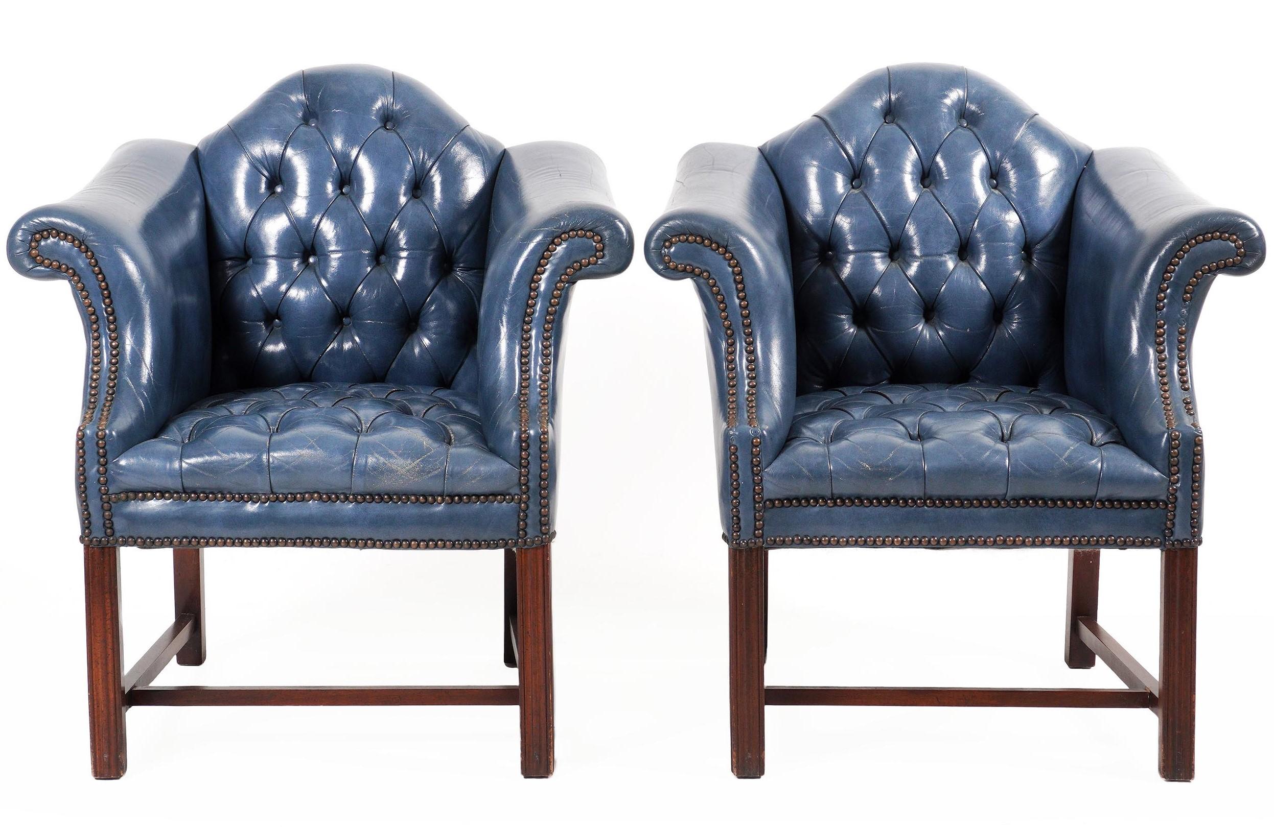 Pair of English blue leather wing back Chesterfield chairs, each one with tufted and nail head detail, custom blue leather upholstery raised on four mahogany Marlborough legs, with 'H' stretcher. Clean and simple lines great patina, some minor signs