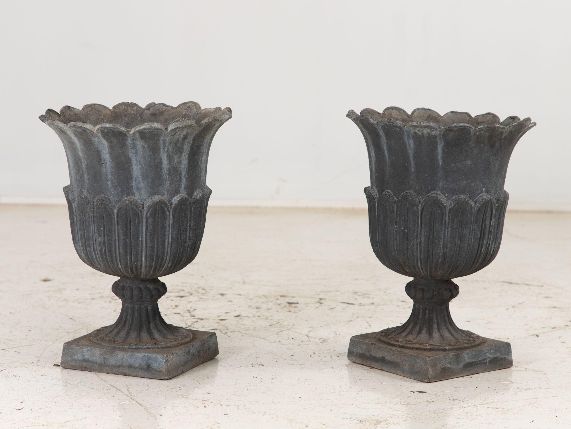 This exquisite pair of antique French tulip garden urns are a testament to timeless elegance. Crafted with meticulous care, each urn is made from durable and sturdy lead, ensuring longevity and durability. The intricate detailing of the tulip petals