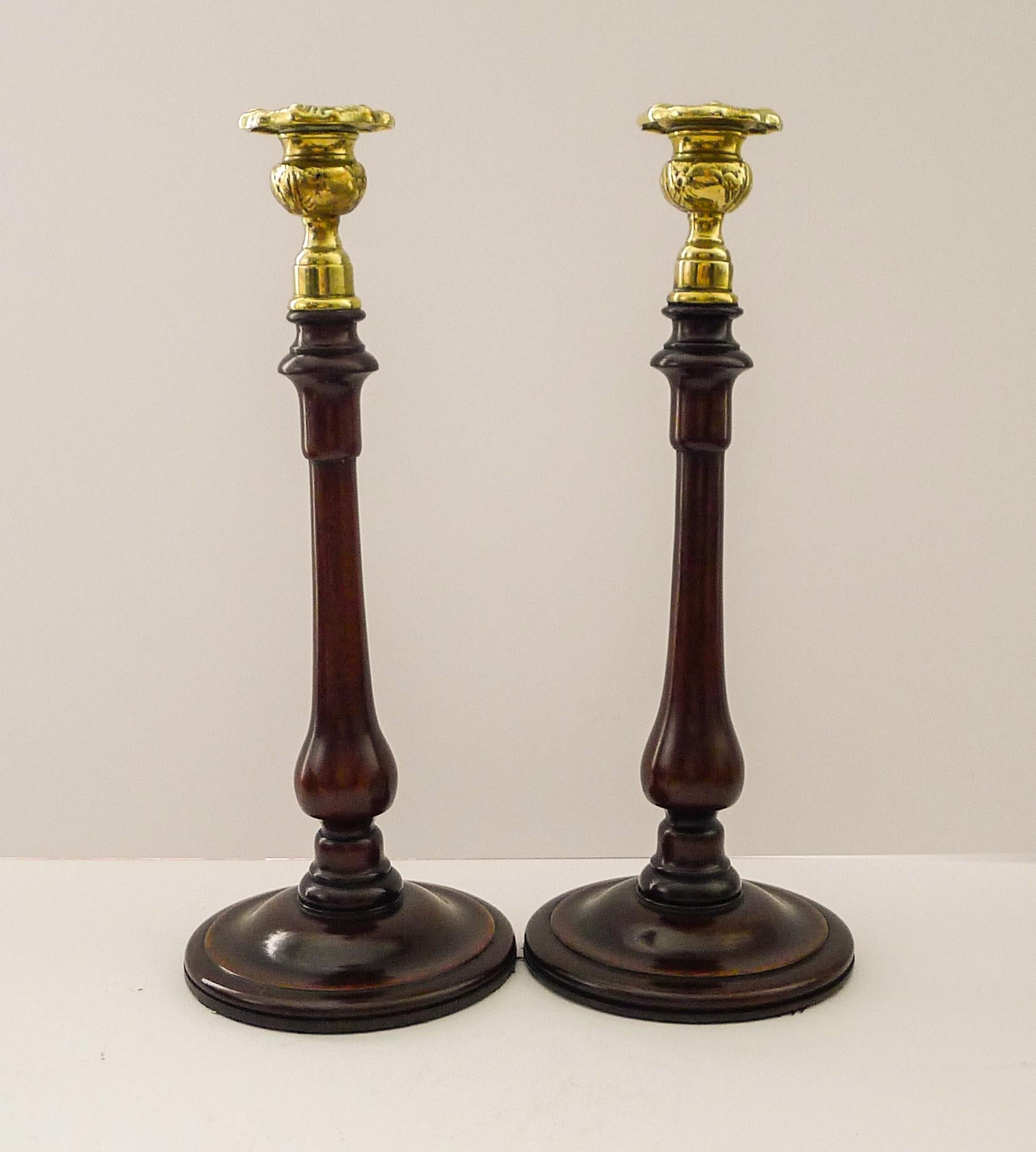 A handsome pair of antique wooden candlesticks beautifully turned to create an elegant silhouette and topped with a thistle design brass top.  

Dating to c.1900, they remain in excellent polished condition, measuring 4 3/4