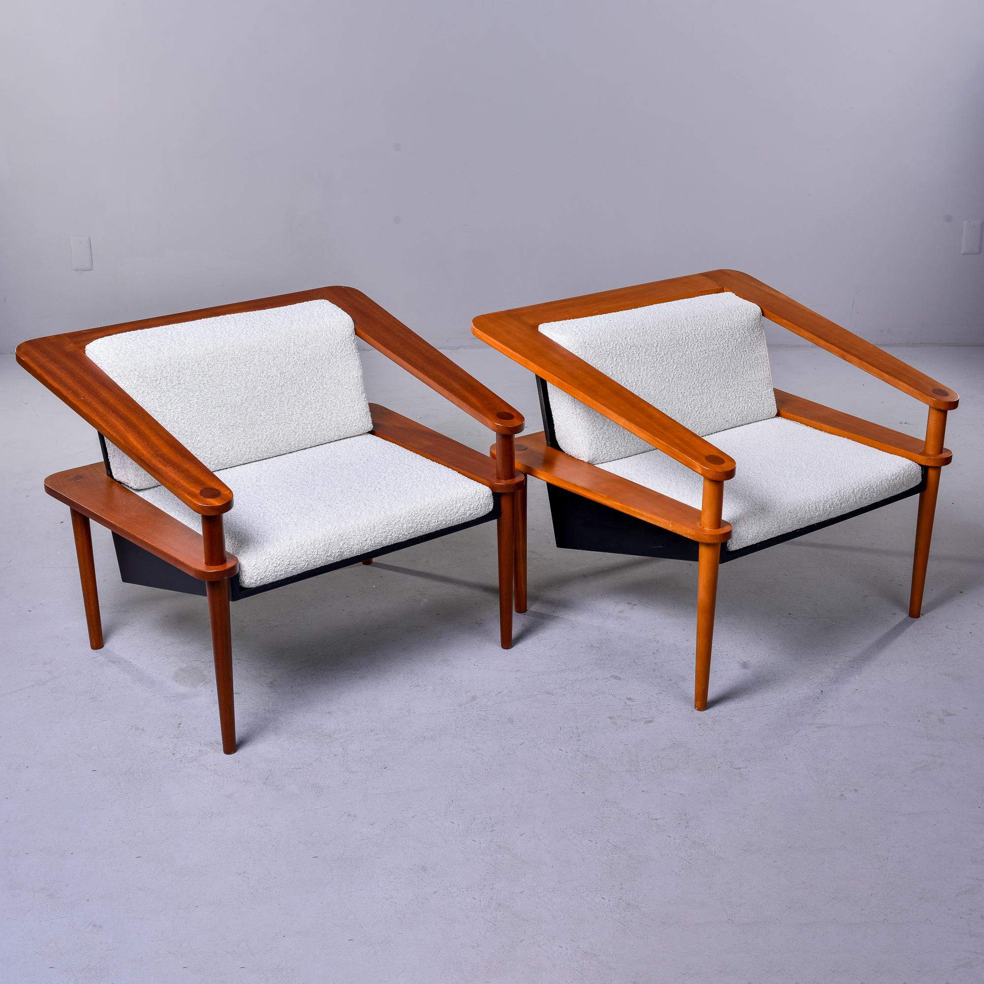Found in Italy, this pair of circa 1980s teak framed open cube-style chairs have a great sculptural quality. Chair seats angle back and show off the open work sides, tapered legs and flat arms and back rests. We found the chairs upholstered as shown