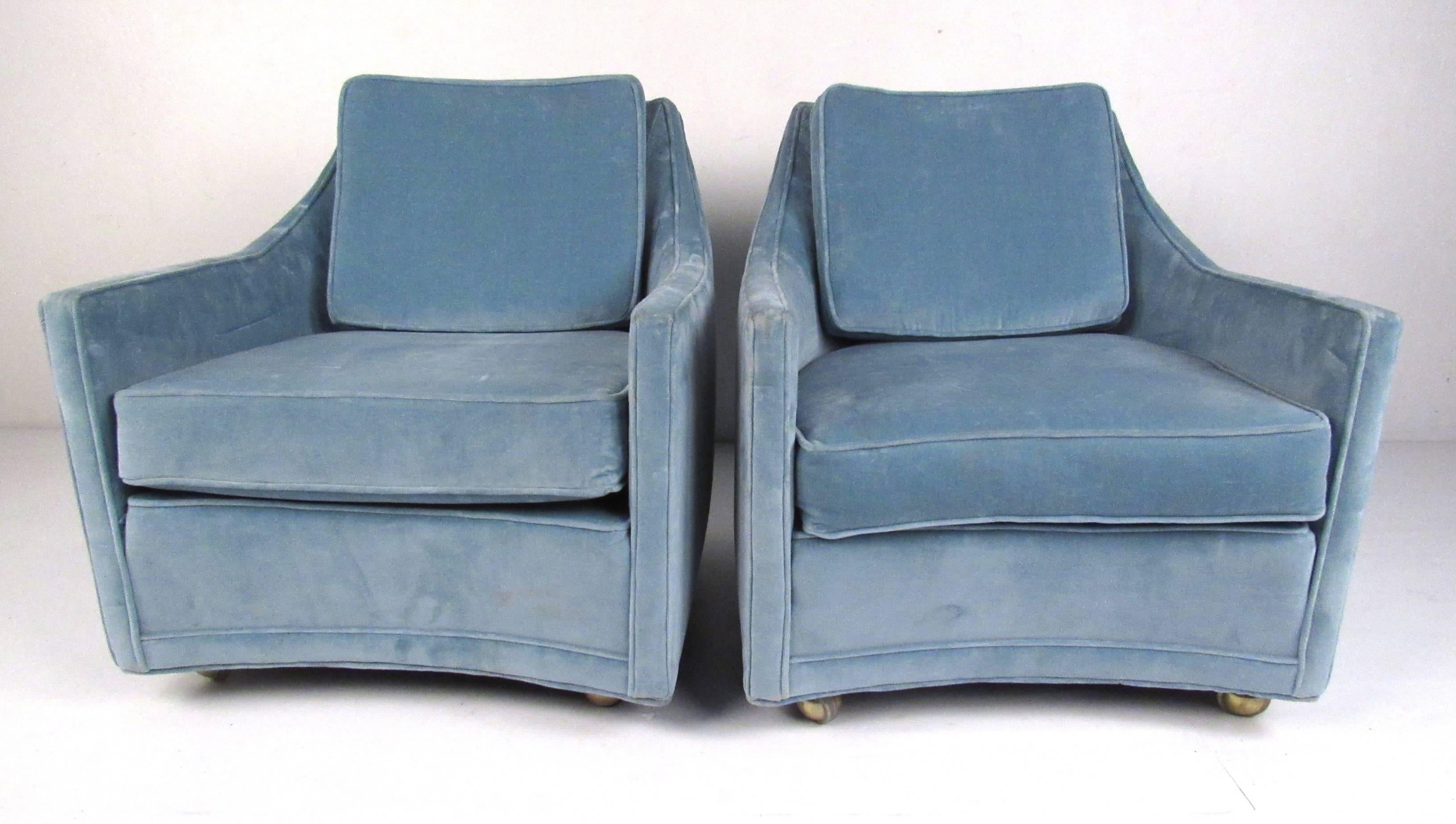 Pair of smaller scale vintage American club chairs with gently sloping arms, comfortable back cushions and casters. Please confirm item location (NY or NJ) with dealer.