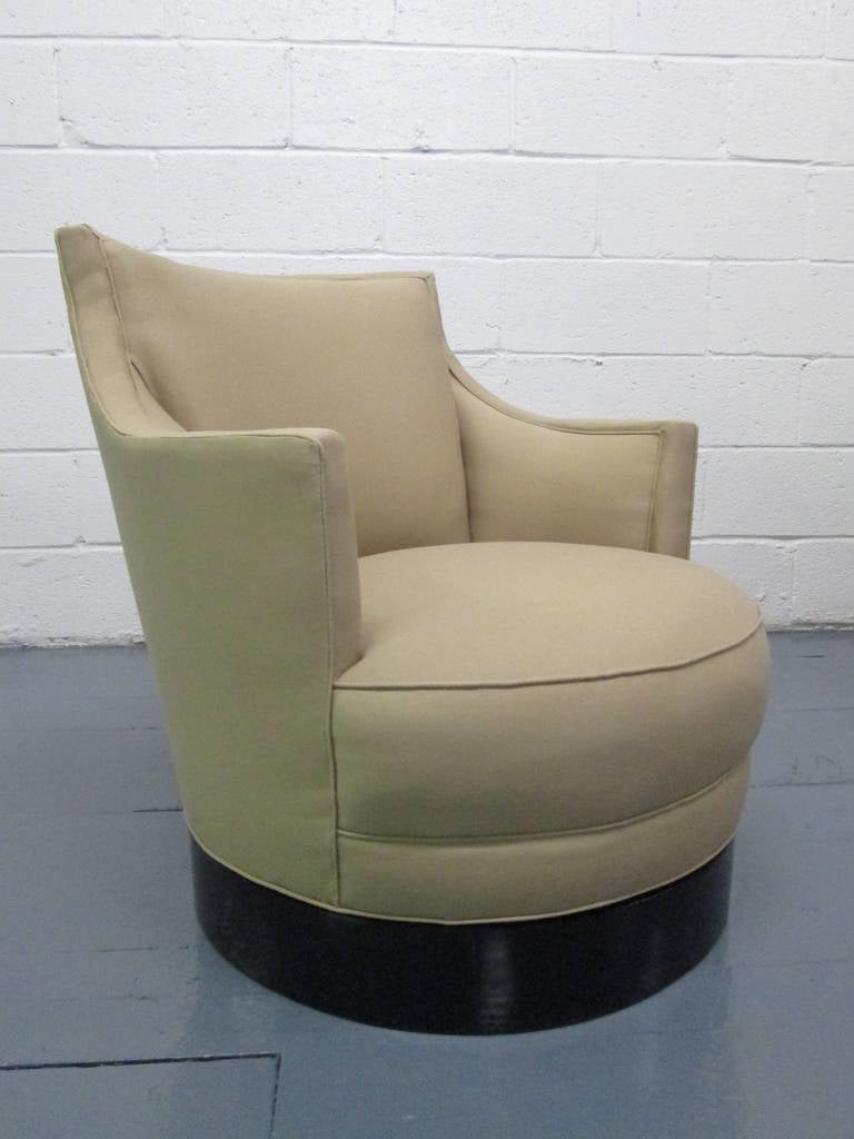 Pair of swivel chairs style of Milo Baughman. Chairs have round black lacquered wood bases.