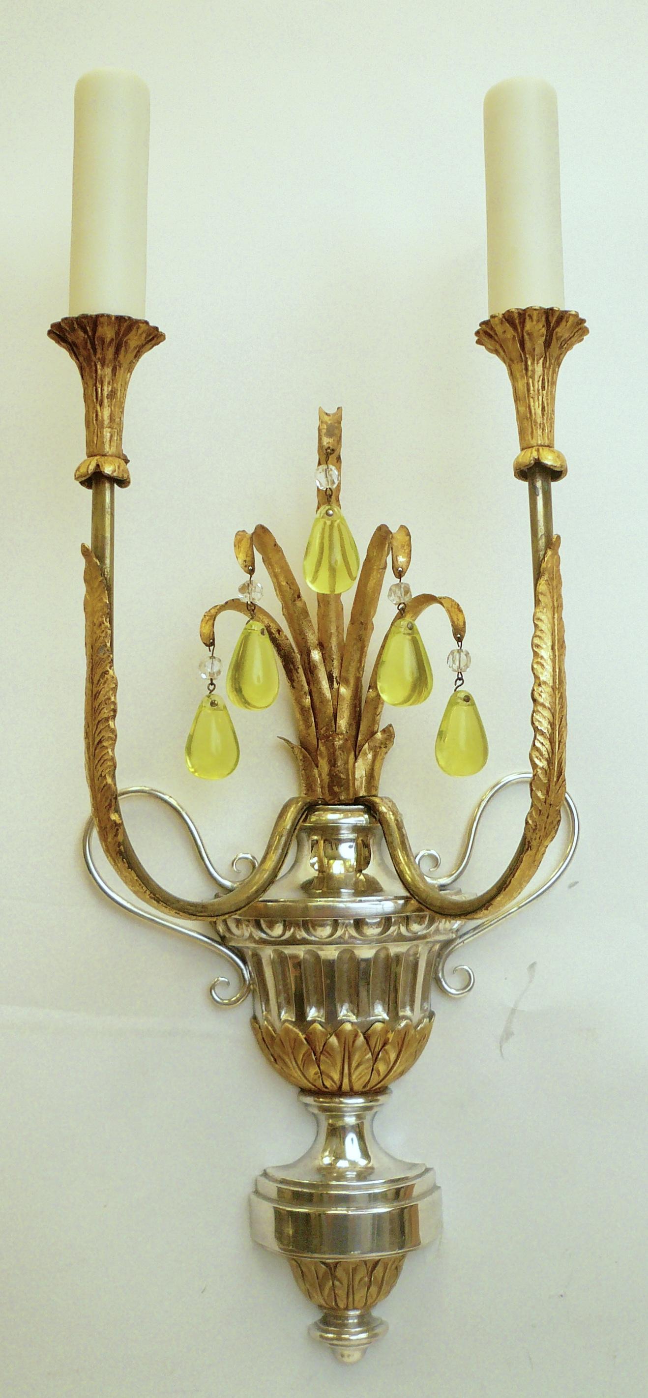 Cette paire d'appliques en argent et plaqué or d'E. F. Caldwell a la forme d'urnes à deux anses de style classique. Les urnes, dont le feuillage doré se termine par des gouttes de cristal chartreuse, sont ornées de feuilles d'acanthe et d'un décor