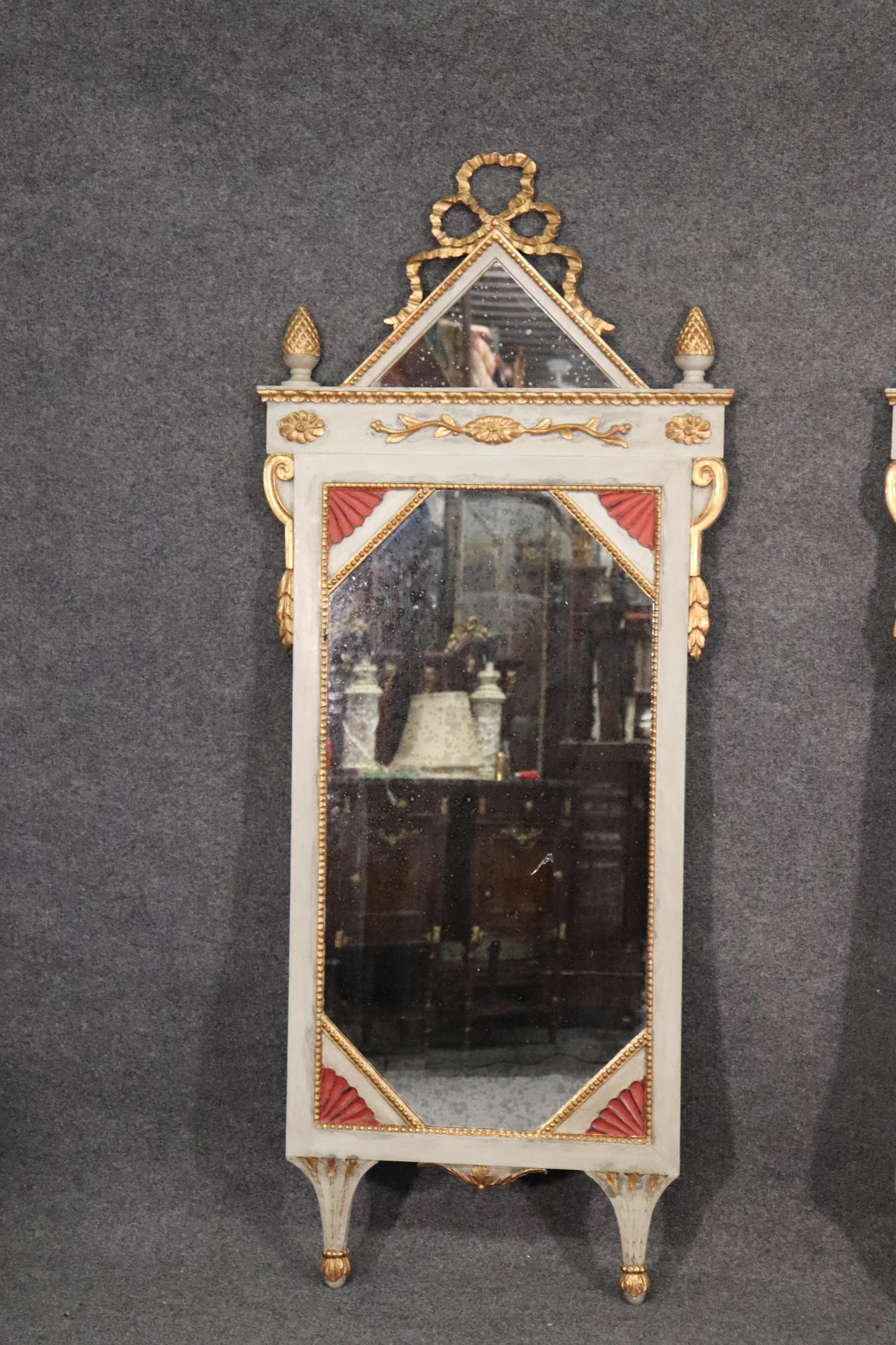 This is a hard to find pair of Venetian paint and gilded carved wood mirrors with their original patinated aged mirror plate glass, circa 1840. They are in good antique condition and will show age spots on the genuine silver mirror plate backs. The