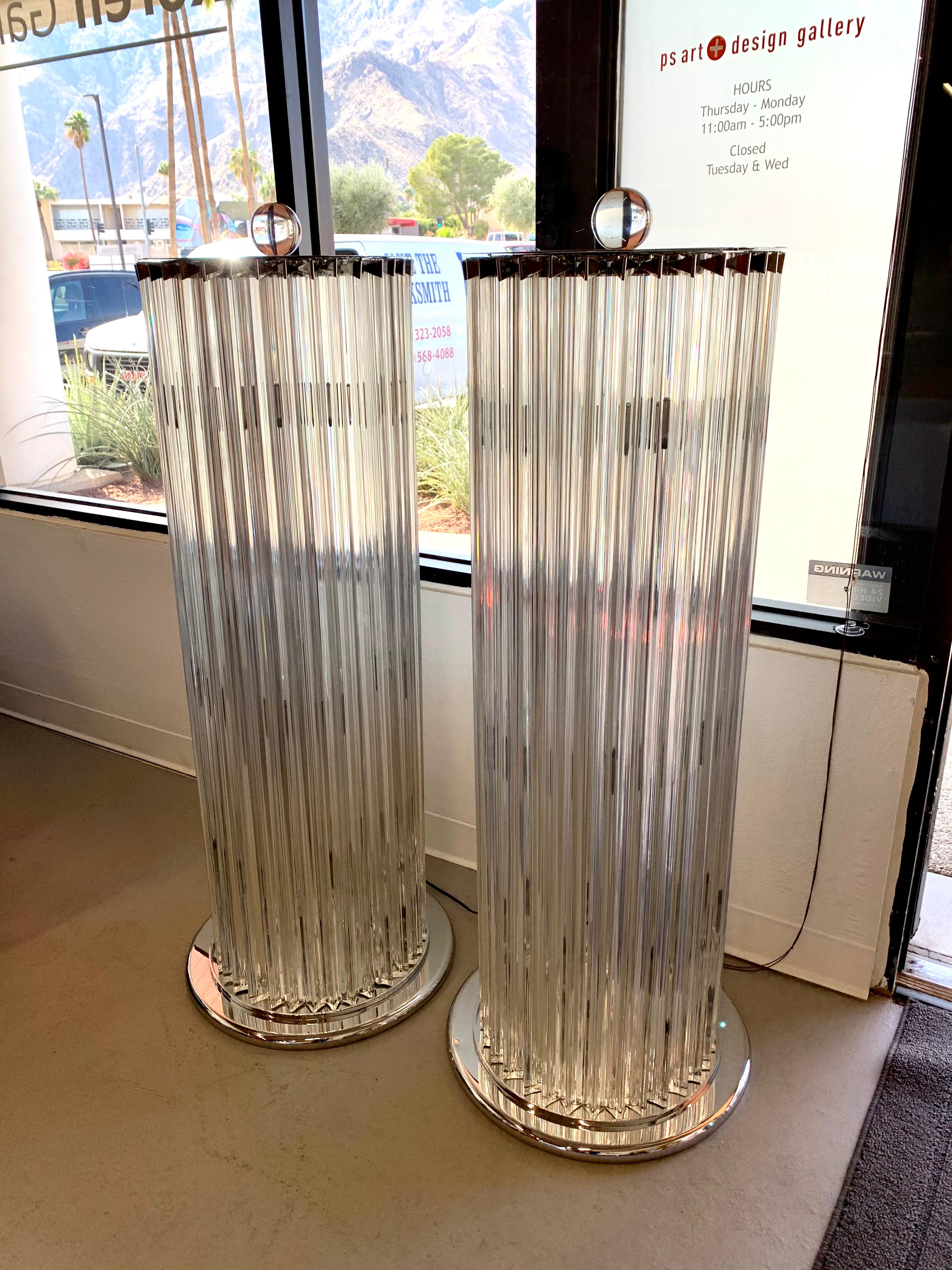 A wonderful pair of Venini Triedri glass lamps with chrome accents. These lamps each feature 8 bulbs inside and one has 32 glass triangular pieces and the other 33. The acrylic finial hold a top chrome plate in place and the triedri pieces fit into