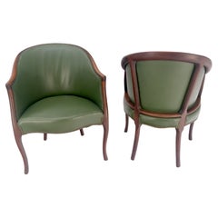 Paire de fauteuils en acajou massif avec dossier en tonneau et tapisserie en cuir