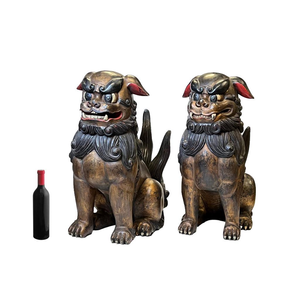 Pair highly stylized large Chinese or Japanese carved wooden guardian lions (fu lions or foo dogs), hand-painted with gilt highlights.