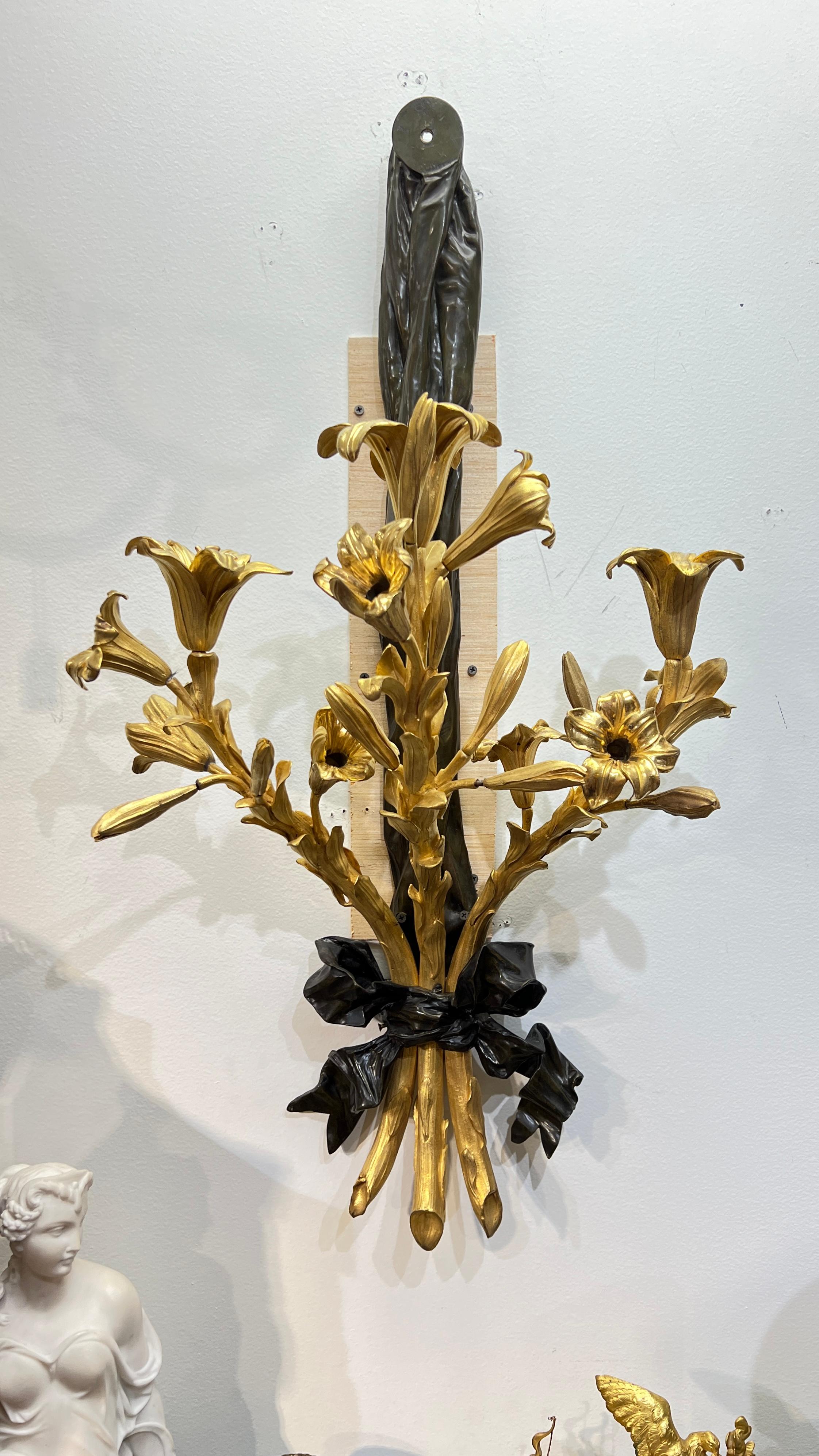 Nos très grandes appliques de style Louis XV / XVI, finement sculptées et moulées, d'une hauteur de 36 1/2 pouces, ont trois grands bras de bougie en forme de branche d'arbre attachés par un ruban à la base. Apparemment non signé.  Peut être