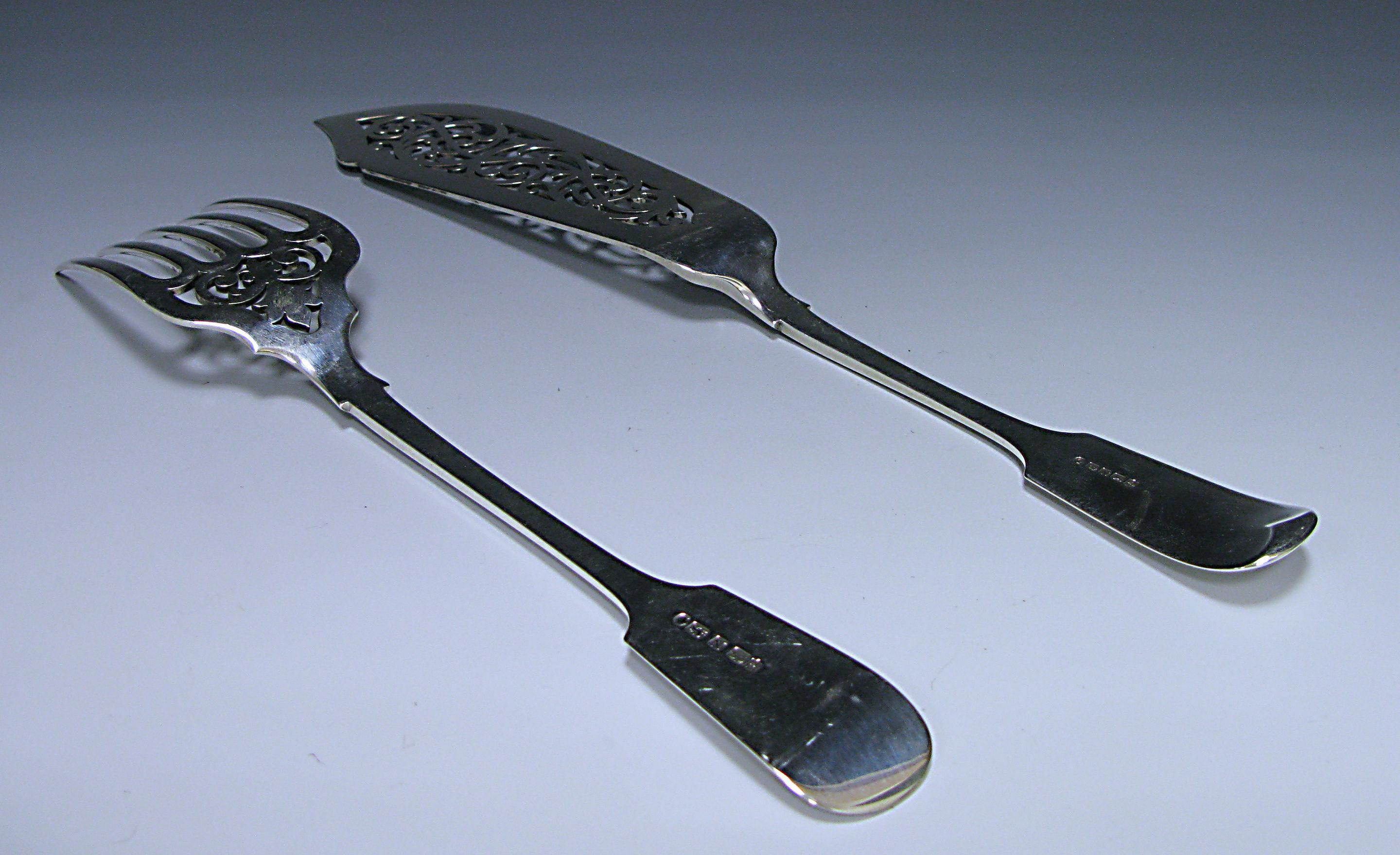 Pair of Victorian antique silver fiddle pattern fish servers. The blade of the knife and top of the fork are embellished pieced scroll decoration. Length of fork 10.43 inches 26.5 cm, Slice 12.67 inches 32.2 cm.
 