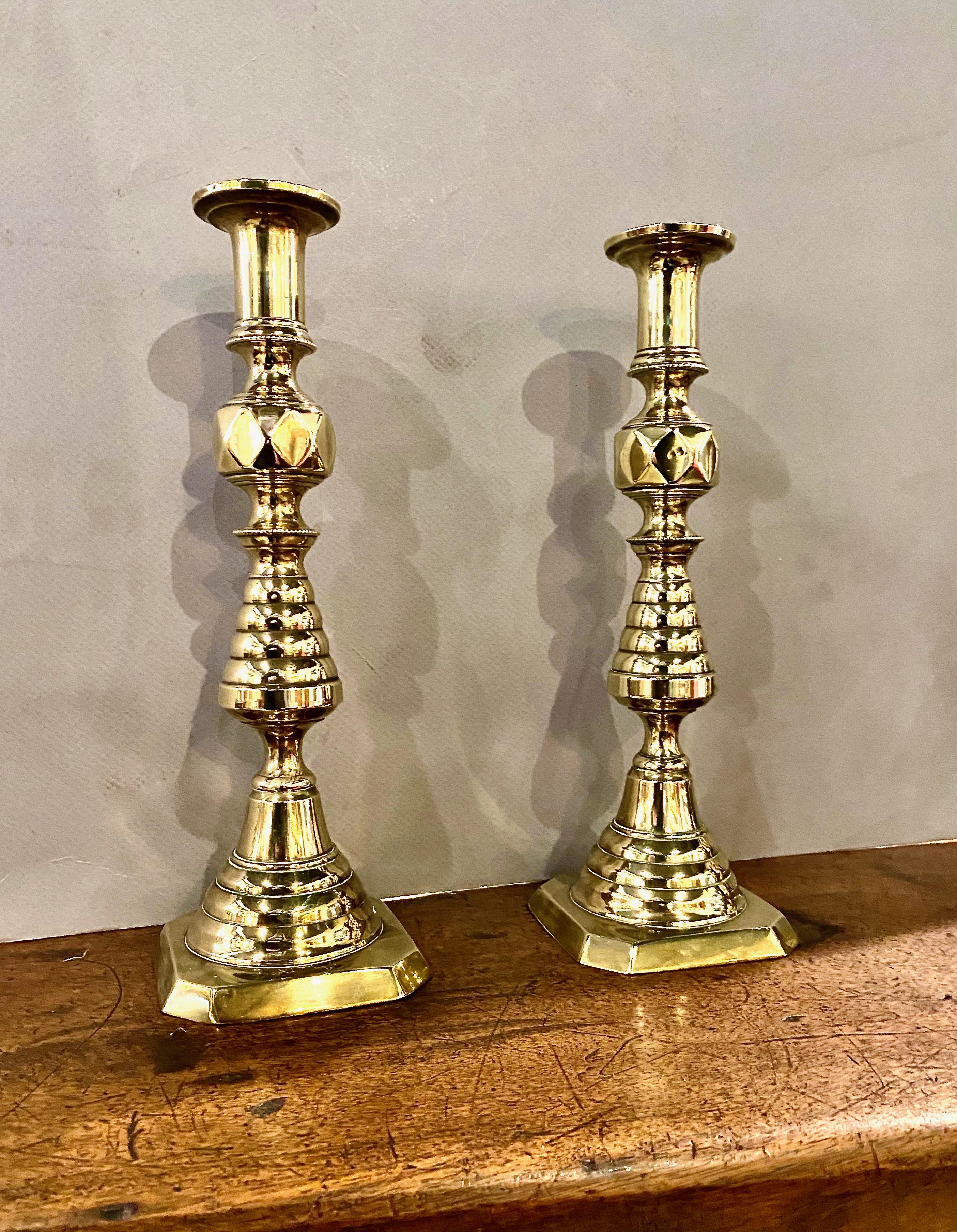 This is a good pair of English Victorian brass beehive and diamond 11 inch candlesticks. This pair is in overall very good condition; the desirable natural patina has been preserved. The round tip of the push-up is missing. The beehive and diamond