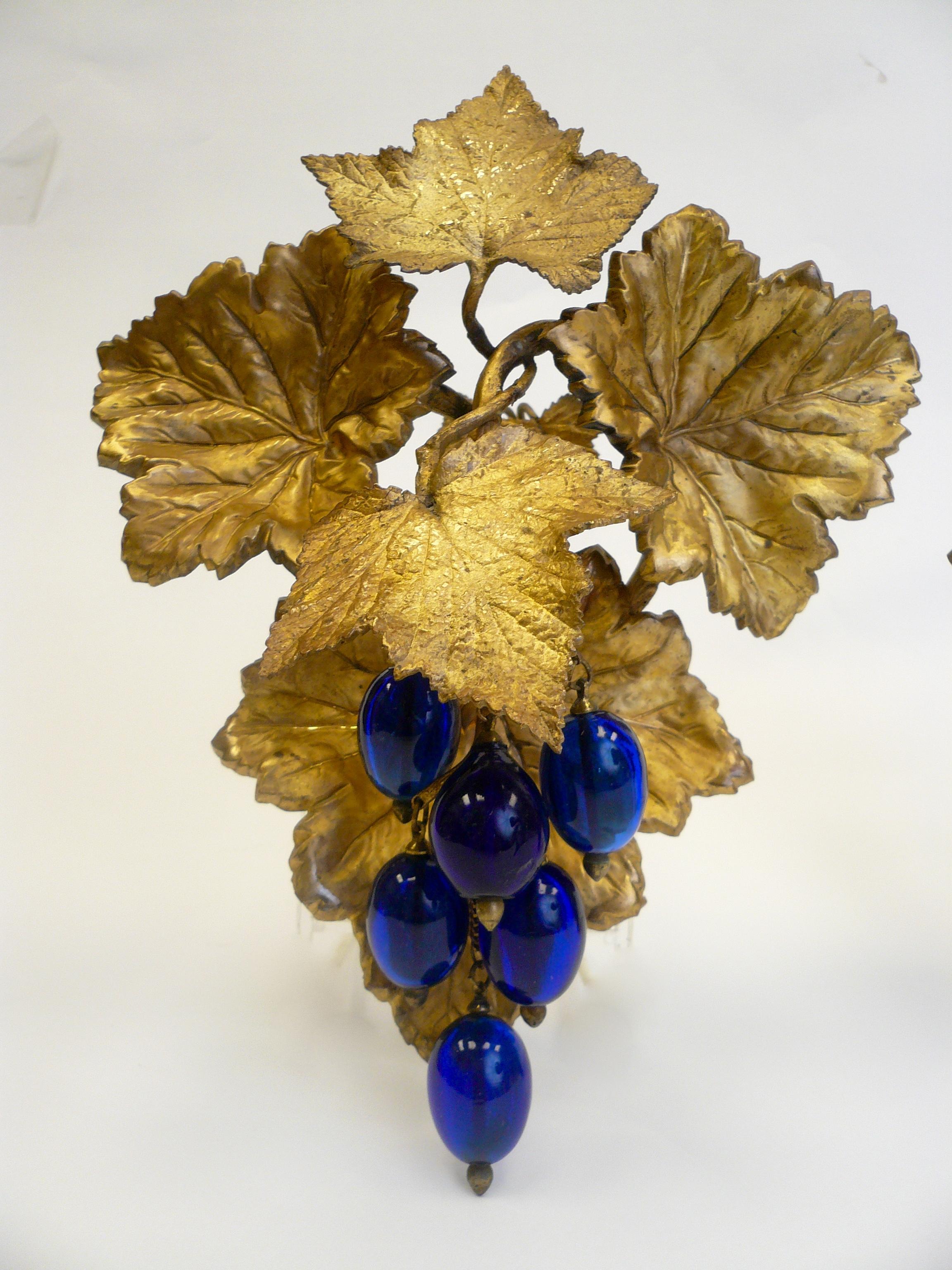 This impressive pair of vintage motif Victorian curtain tiebacks feature cast and repousse gilt brass grape leaves, and cobalt blue blown glass grapes.