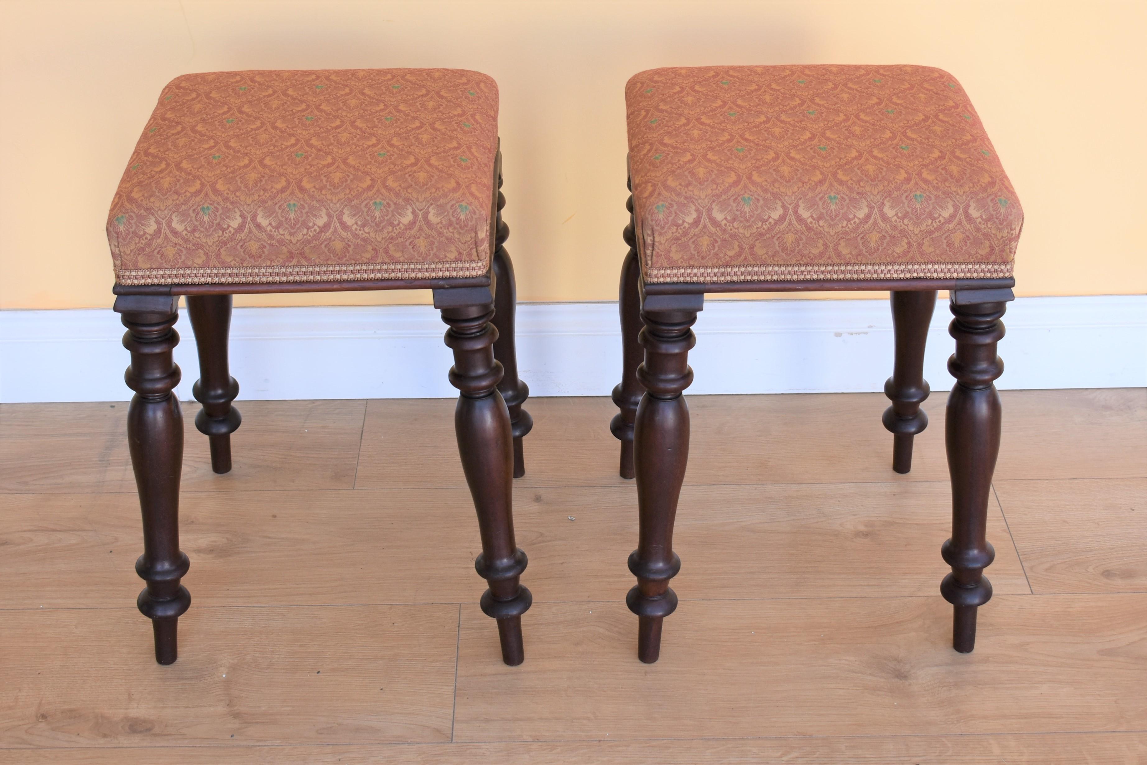 Pair of Victorian mahogany upholstered stools in good condition with turned legs.