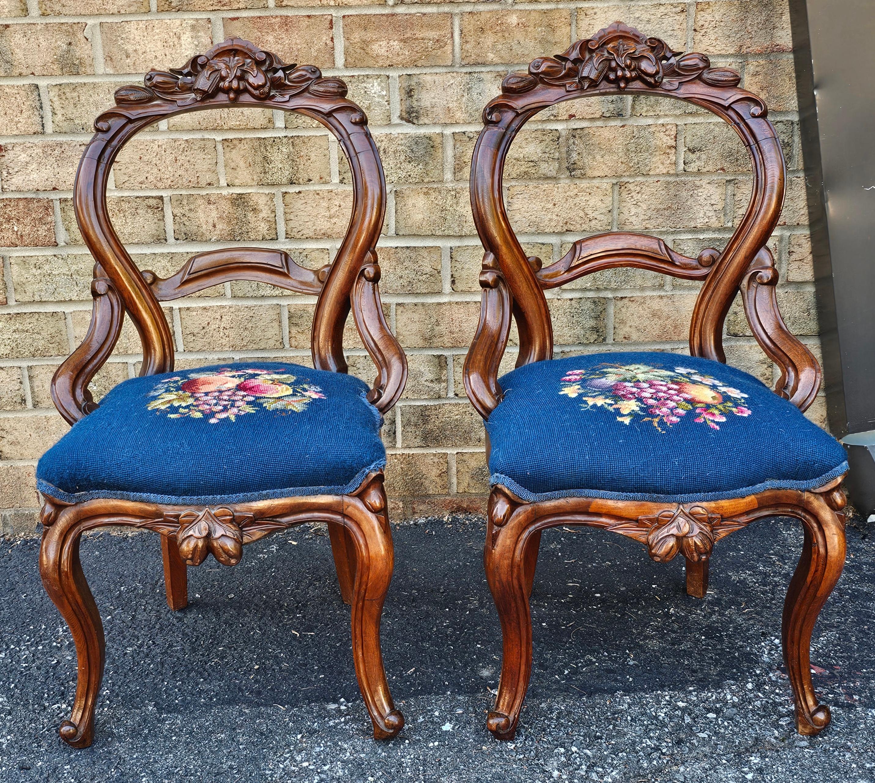 A Pair Victorian Rococo Style Walnut and Needlepoint Upholstered Side Chairs
.Measures 20.5