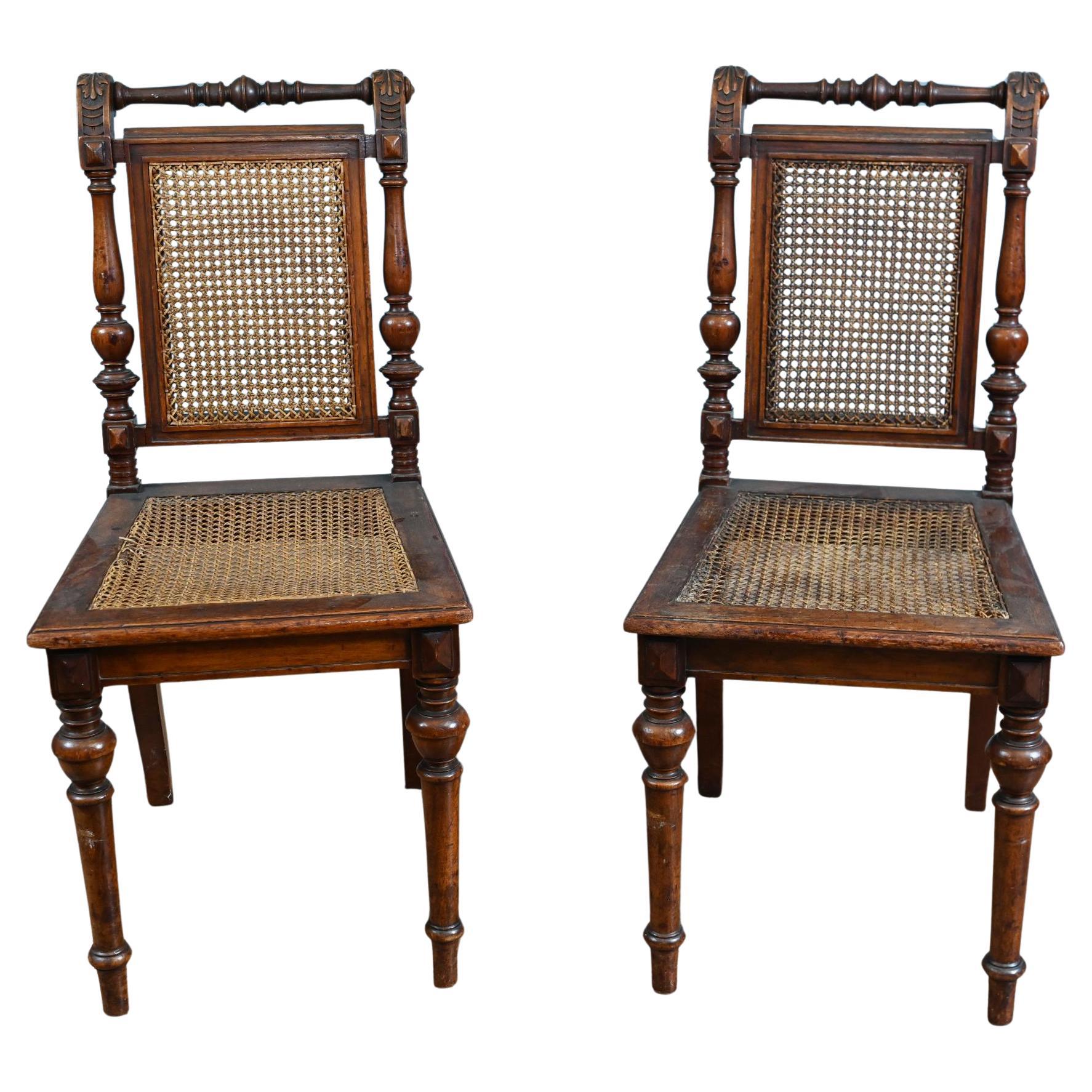 Coppia di sedie laterali vittoriane in legno di noce, con sedute in canne in vendita