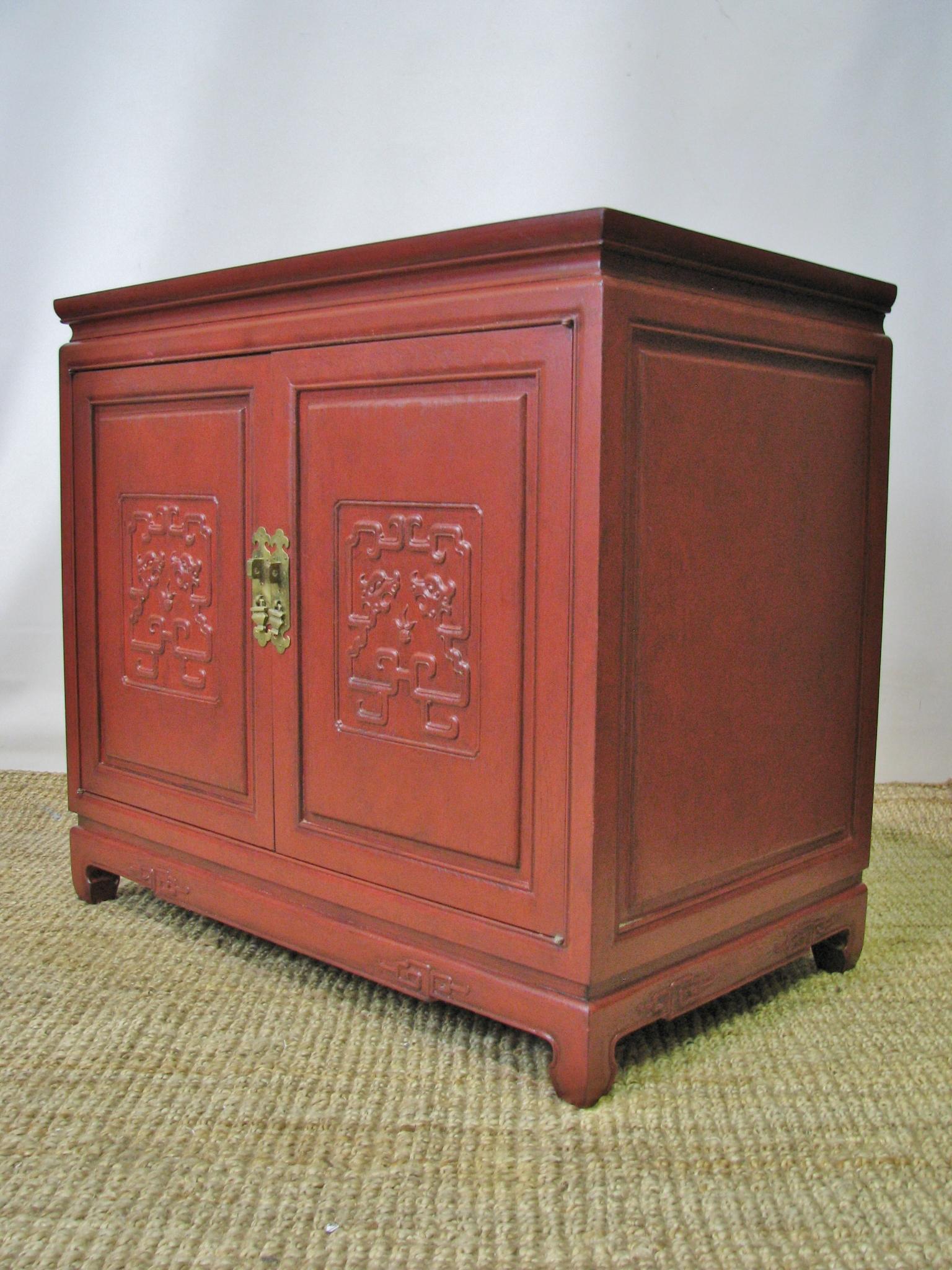 Striking pair of vintage and high end 1960s, Asian style two-door cabinets. Simple and elegant form, set on Ming style feet. Central panels on each door feature Asian calligraphic motifs. The skirt also features these same style details. Raised