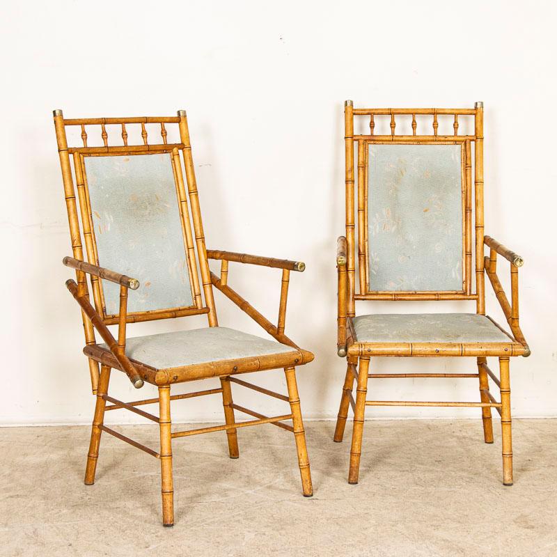 Great lines define this delightful pair of authentic vintage bamboo arm chairs with brass end caps. Restored, this pair sits comfortably and is ready to be used and enjoyed. The seat and back upholstery shows wear and can easily be replaced at