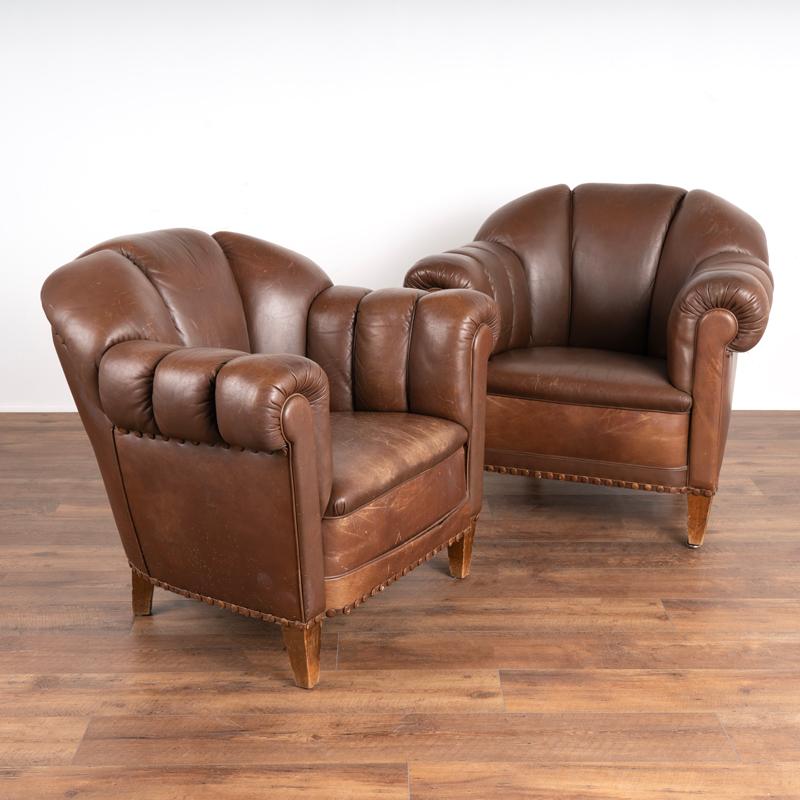 Vintage leather club chairs are sought after these days for those seeking to add an aged element to a modern home. These welcoming arm chairs will do just that; they are scaled to fit in a variety of settings and have self-trim piping. This pair
