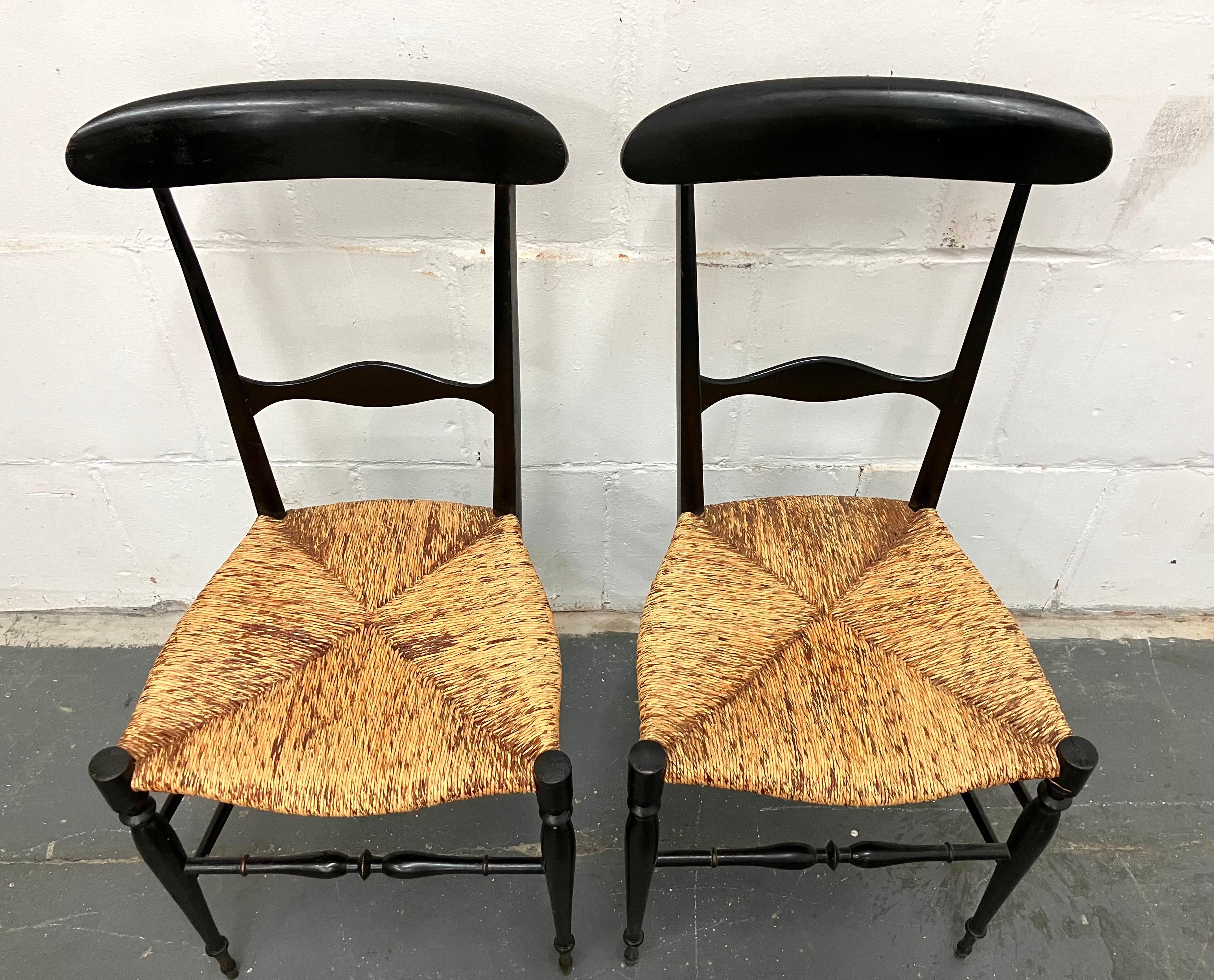 Paar leichte und elegante Chiavari-Esszimmerstühle aus den 1940er Jahren. Der ursprüngliche Entwurf stammt aus dem frühen 19. Jahrhundert von Giuseppe Gaetano Descalzi. Lackiertes Holz mit originalen Binsen-Sitzen. Diese Version war das Modell, das
