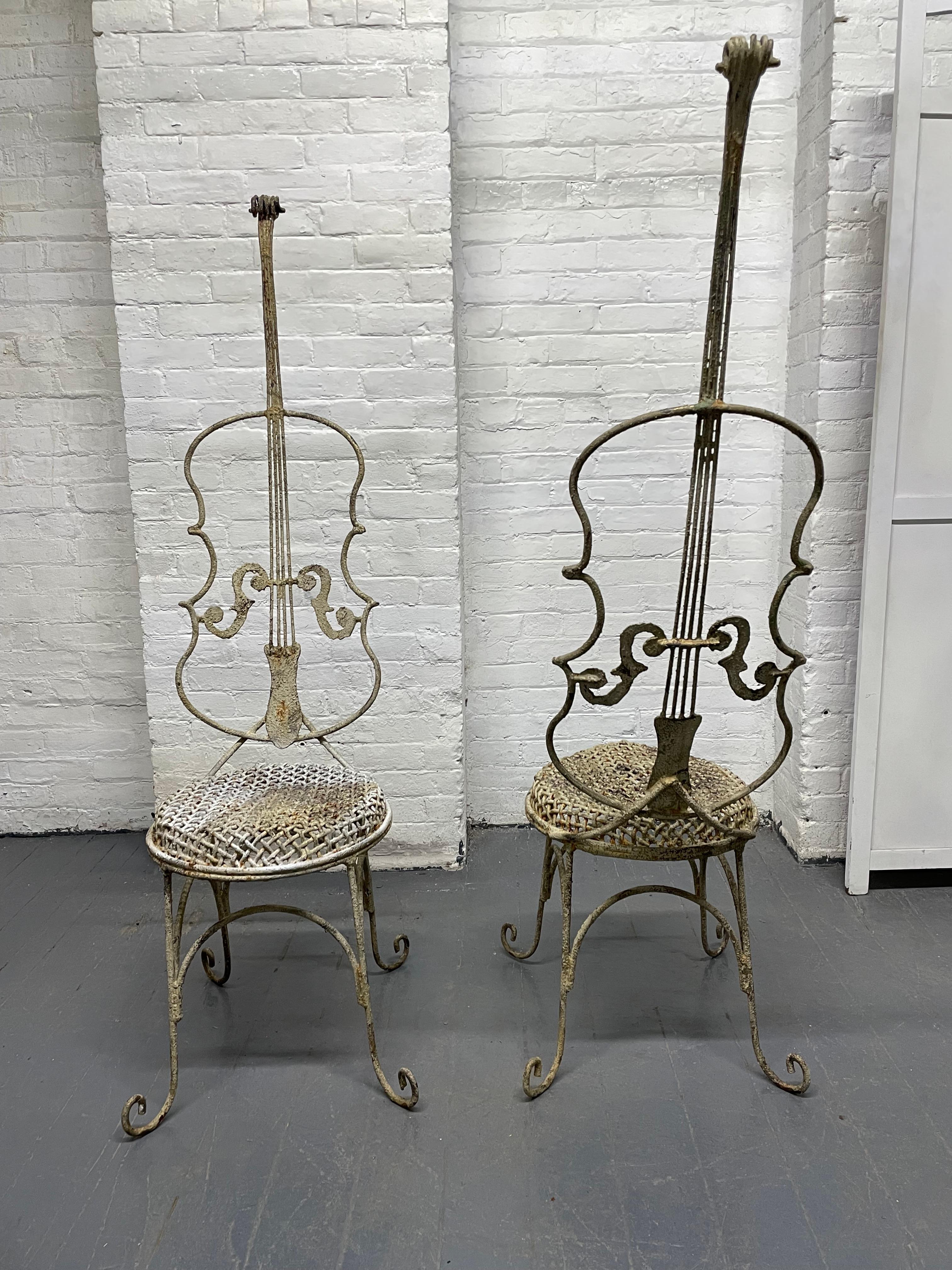 Pair of vintage painted iron cello-form chairs. The chairs have scrolled feet, tall backs and basket weave style raised circular seats.
