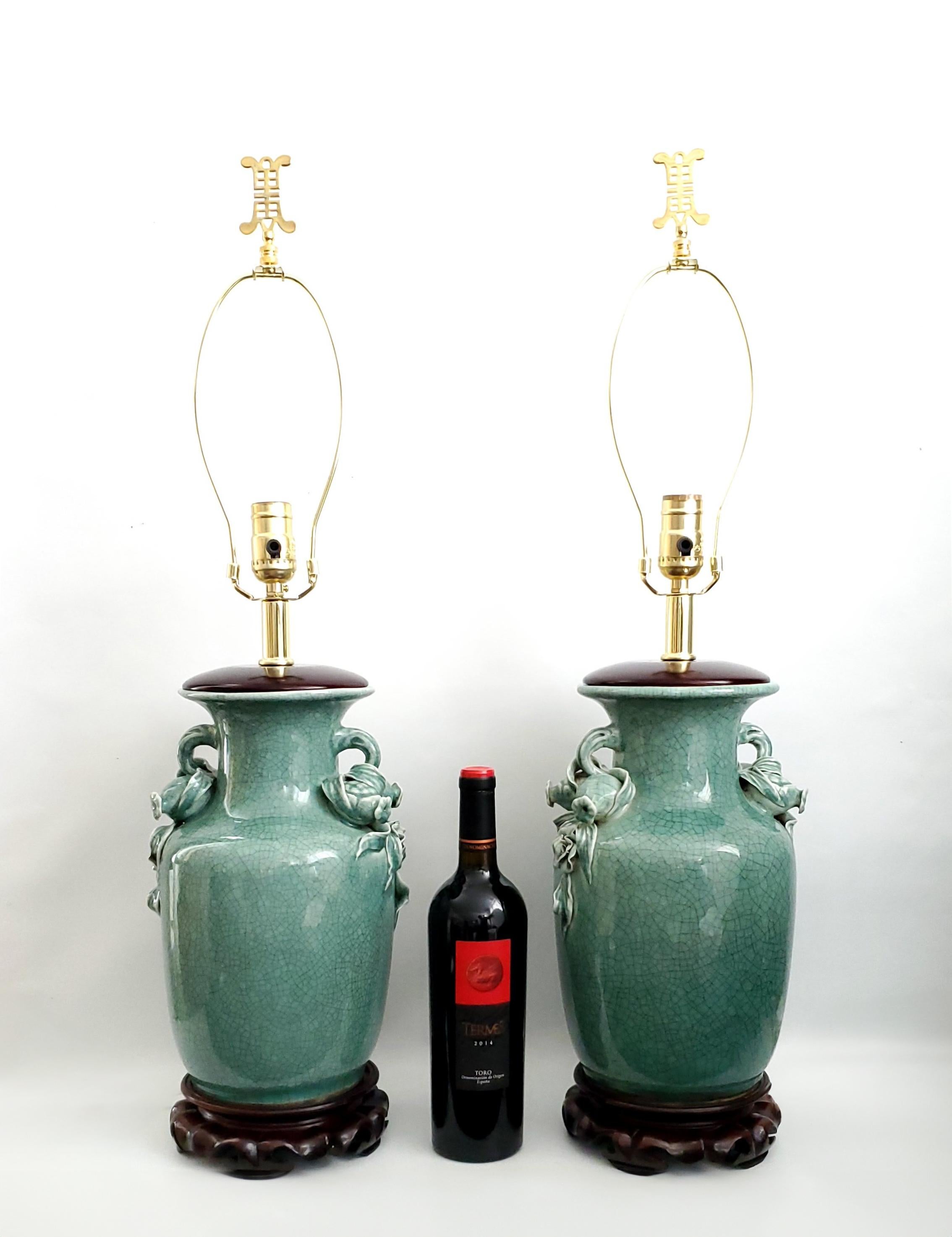 Pair of Hand Painted Vintage Chinese Porcelain Table Lamps with Three Dimensional handles decorated with pomegranates, roses and leaves, circa Mid 20th Century.  These gorgeous hand painted lamps have a beautiful green intentionally crackled high