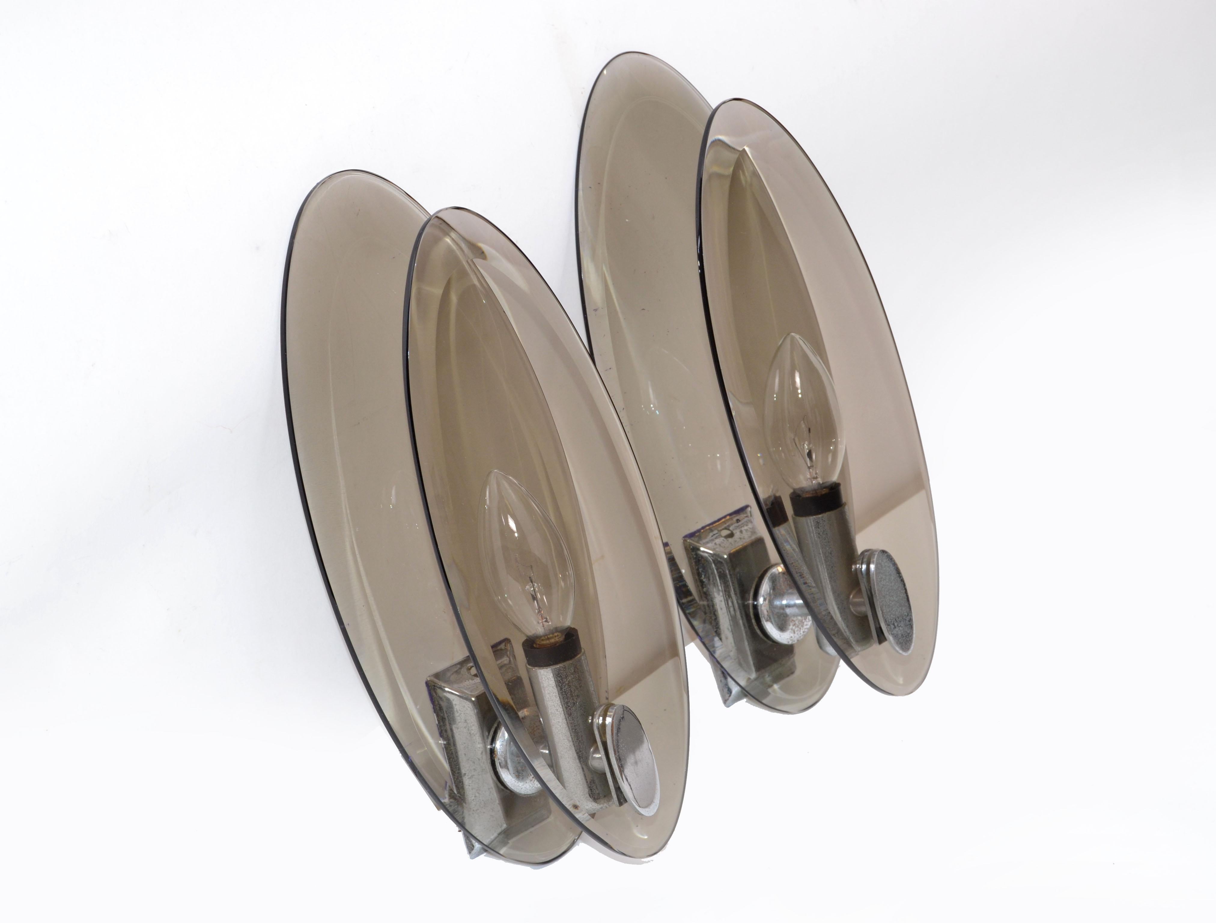 A pair of Italian Mid-Century Modern sconces by Fontana Arte featuring oval panels of smoked, beveled glass.
U.S. wired and in working condition.
Each sconce takes one 40W bulb per sconce.
Back plate: 3.75 inches H. x 1.25 inches W.