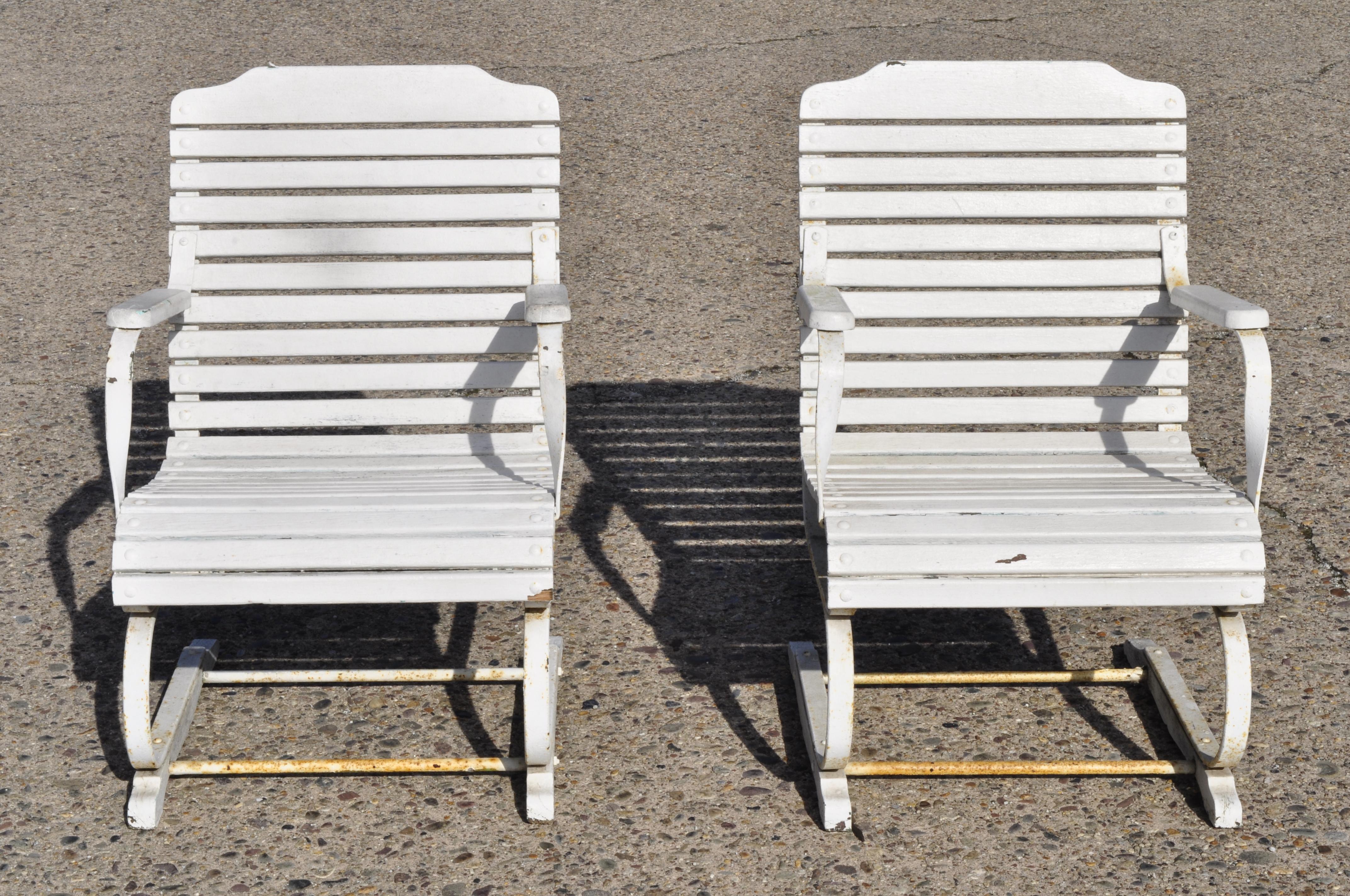 Pair of vintage French country wrought iron and wood slat bouncer garden lounge chairs. Listing includes wooden slat seats, heavy iron frame, very nice antique item, great style and form, circa early to mid-20th century. Measurements: 34