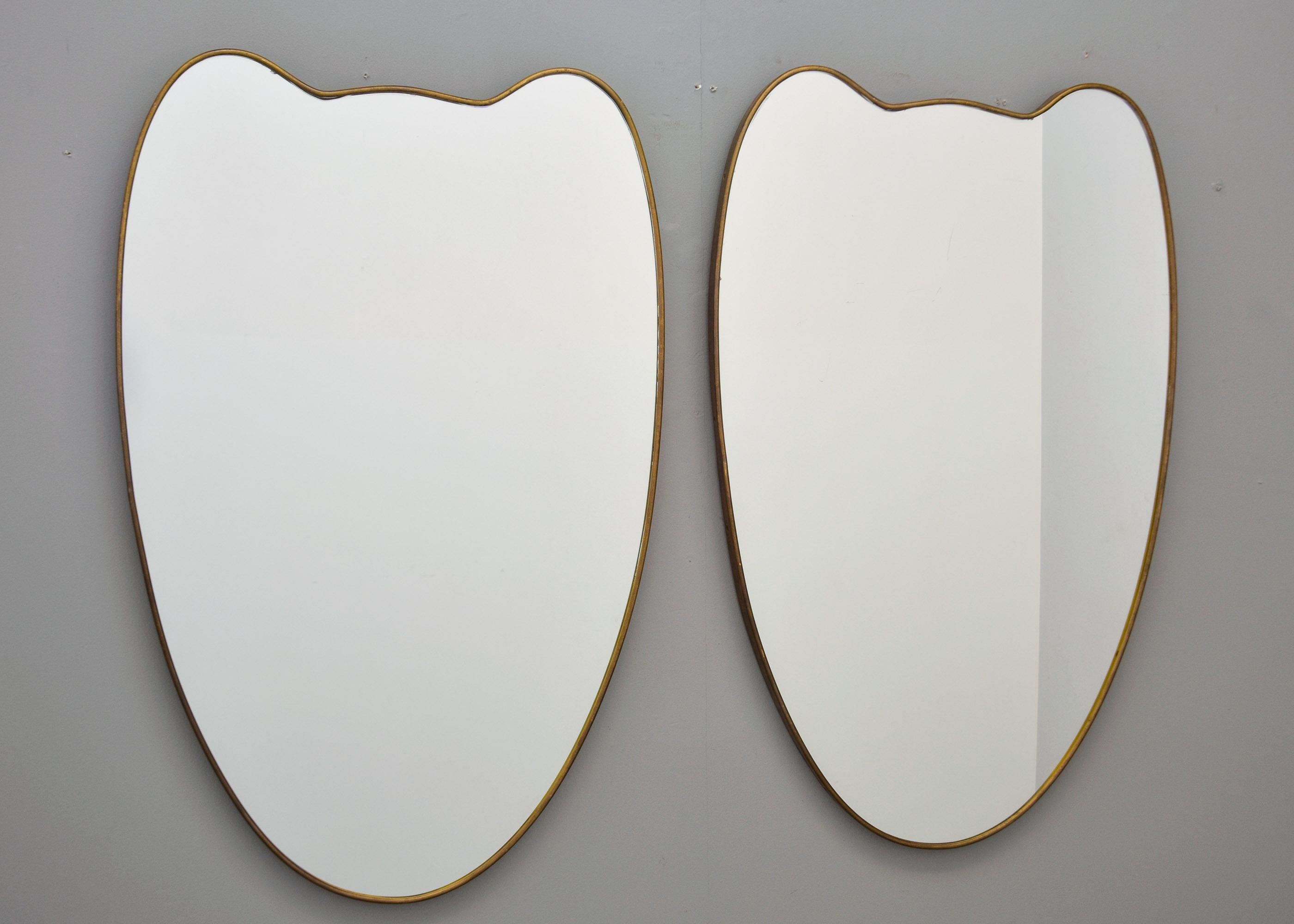 Italiano Coppia di specchi d'epoca in stile Gio Ponte con cornice in ottone a forma di scudo in vendita