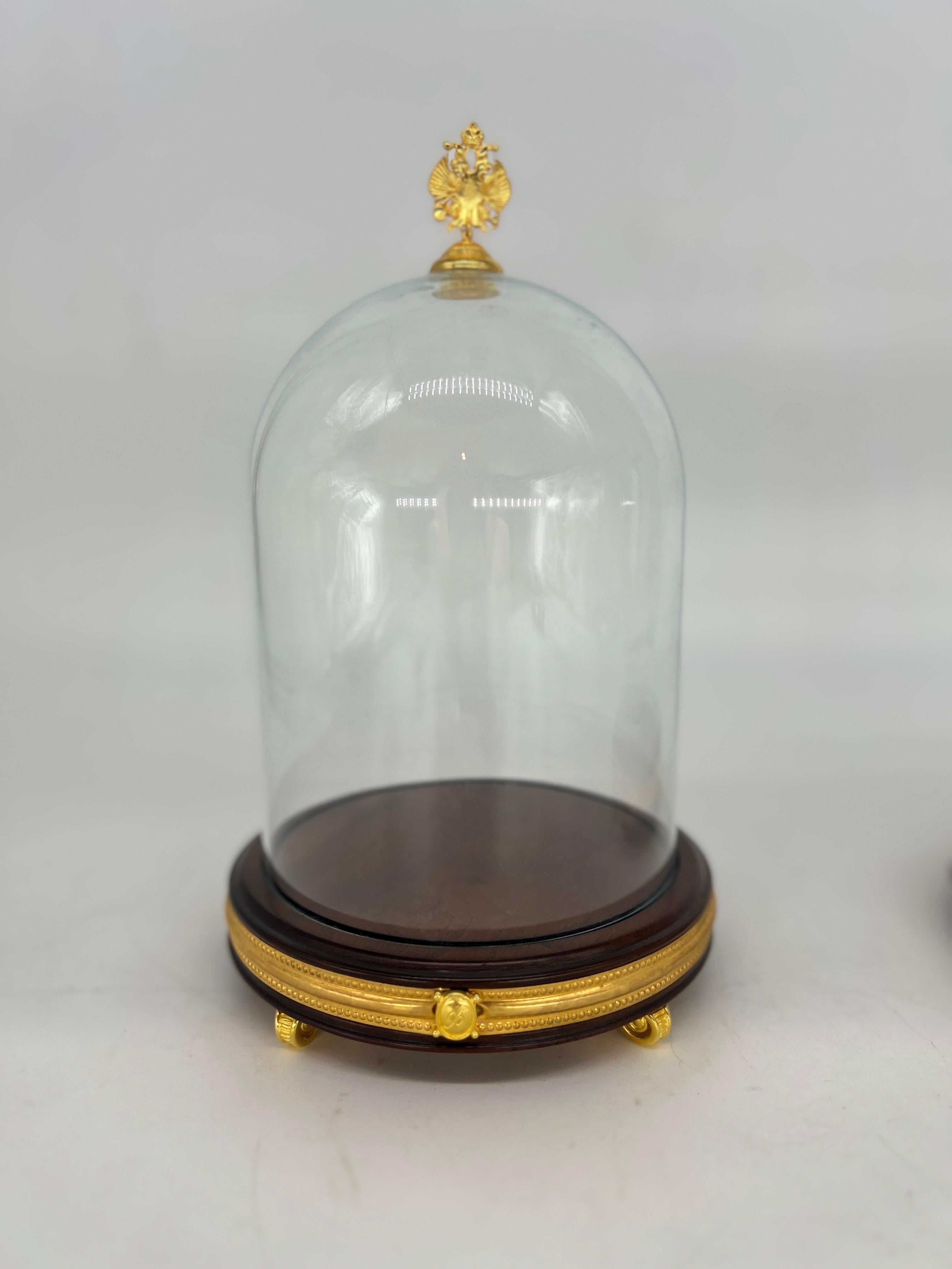 The pair of vintage House of Fabergé Ormolu mounted glass display domes is a truly exquisite find for any collector or lover of fine craftsmanship. These elegant domes are meticulously crafted with a combination of Ormolu, a gilded bronze, and