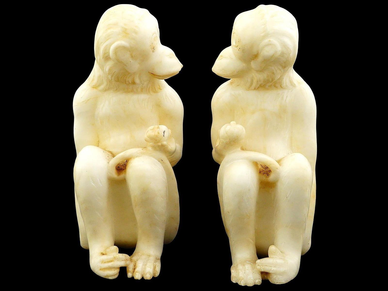 Coppia di statuette vintage italiane scolpite a mano in pietra d'alabastro che raffigurano macachi seduti con in mano delle mele.  Misura circa 9 x 5 x 4 pollici.