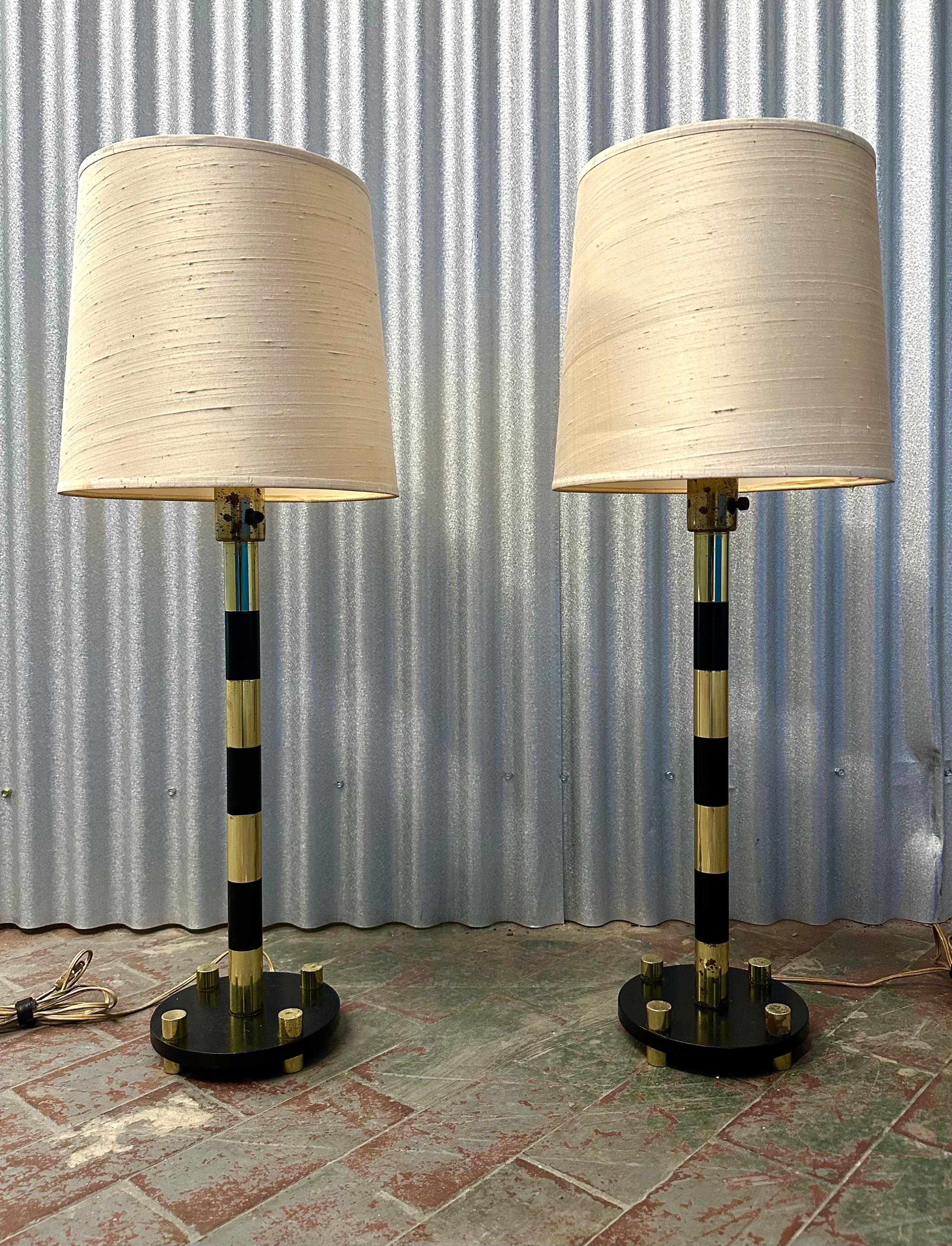 The stem and base are comprised of alternating polished brass and black enameled brass bands. 

An elegant design with a slightly Space Age feel. Wired with a single upright socket. Sold without shades, but sample pair may be available.