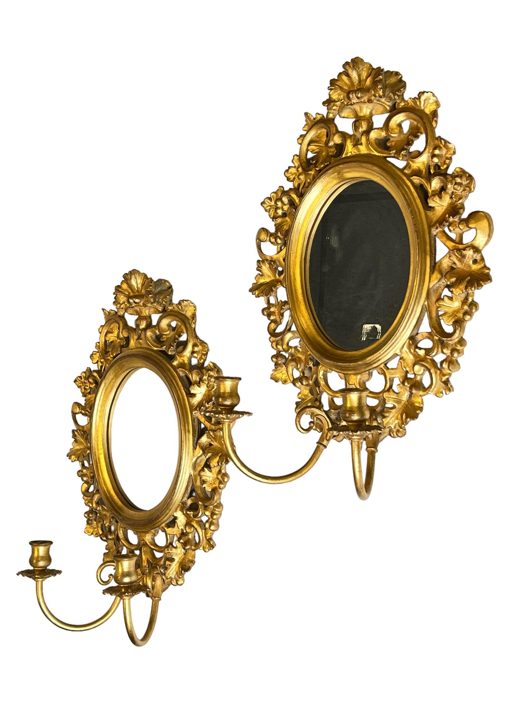 Pair vintage Italian neoclassical giltwood and gilt metal girandole wall lights with oval mirrors and two lights.  