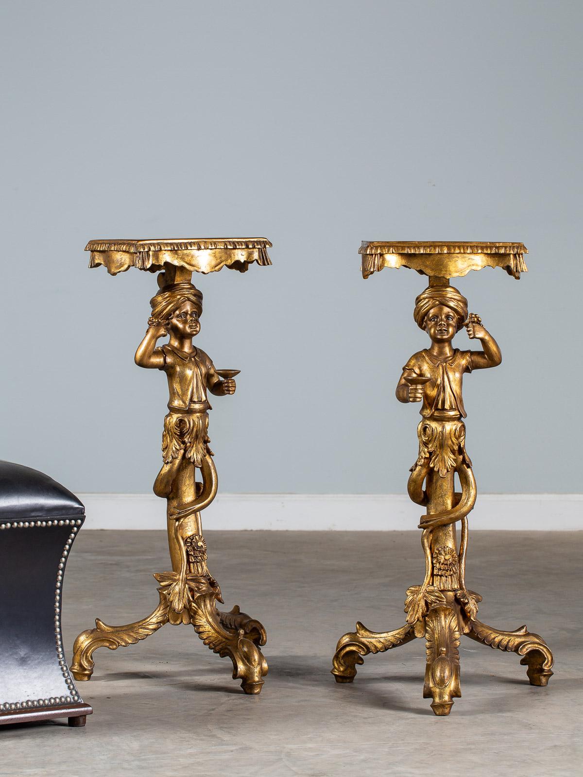 A pair of vintage Italian Venetian gilded Blackamoor pedestal column figures circa 1950 each holding aloft a cluster of grapes and a goblet. Please notice the figures are facing each other with the grapes and goblets in opposite hands. The top of