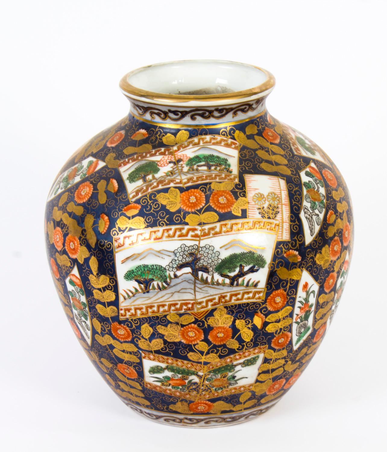 A beautiful pair of hand-painted porcelain vases in the Imari style, mid-20th century in date.

The rotund shaped vases are decorated in a rich cobalt blue ground with paneled landscape scenes, with high lights in coral and gold.

Add some