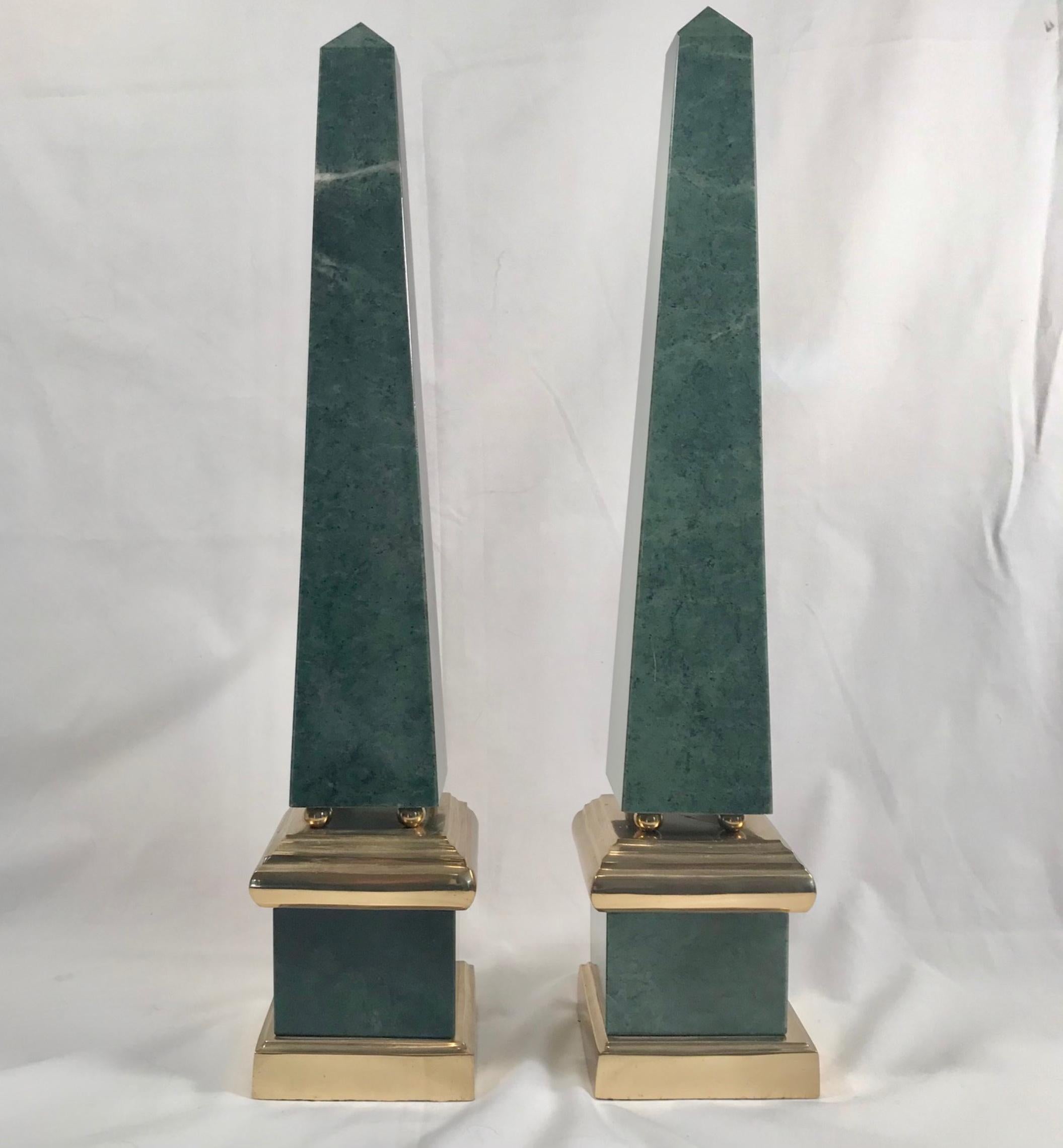 Pair of vintage large green obelisks, brass mounted

The matching pair of impressive green marble (Antico Verde) obelisks are created in large scale and mounted in brass. A brass base supports rich green veined marble that rises to meet a brass