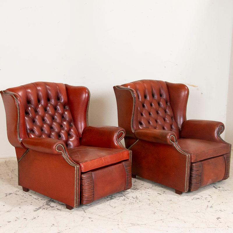 Vintage leather chairs are always a fun find, but this is the first time we have acquired a pair of vintage recliners. The wingback Chesterfield style is distinctive with the tufted backs and handsome nailhead trim. The tan leather has a reddish