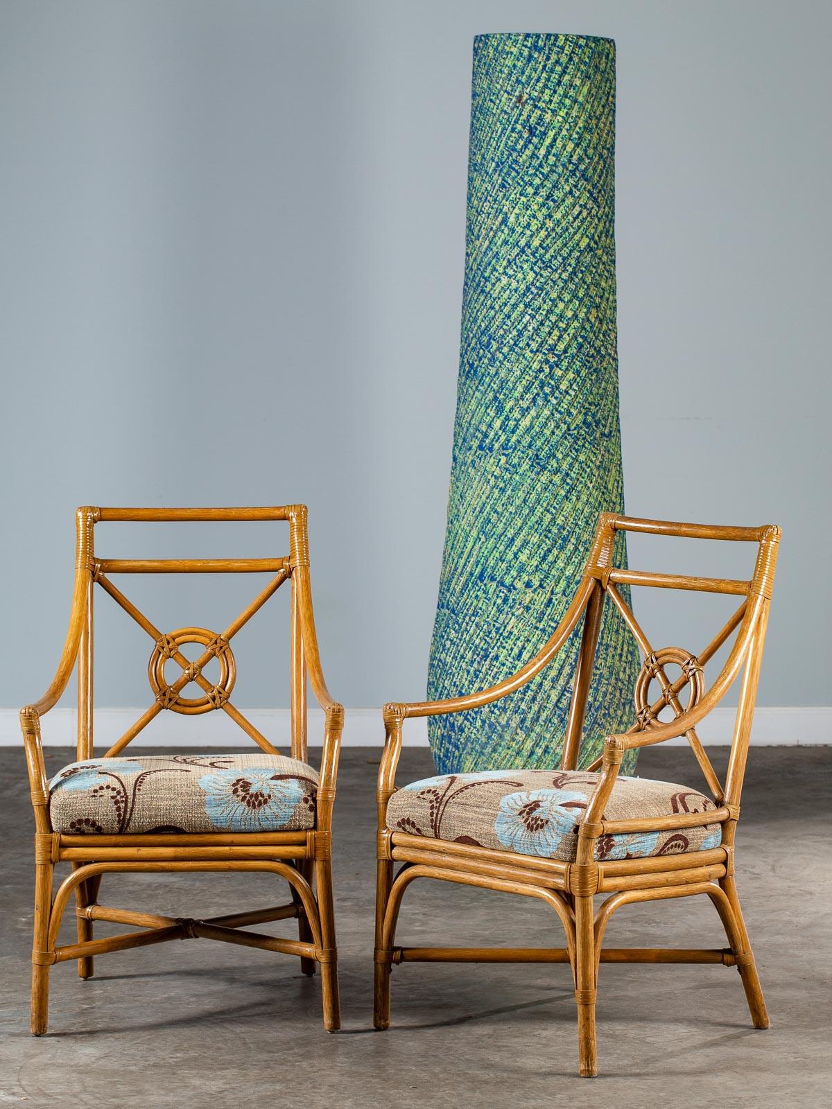 A pair of chic vintage McGuire bamboo chairs with rawhide strapping in the famous Target Backsplat design circa 1970. This pair of classic American armchairs feature a freshly upholstered seat that complements the clean and modern profile. Please