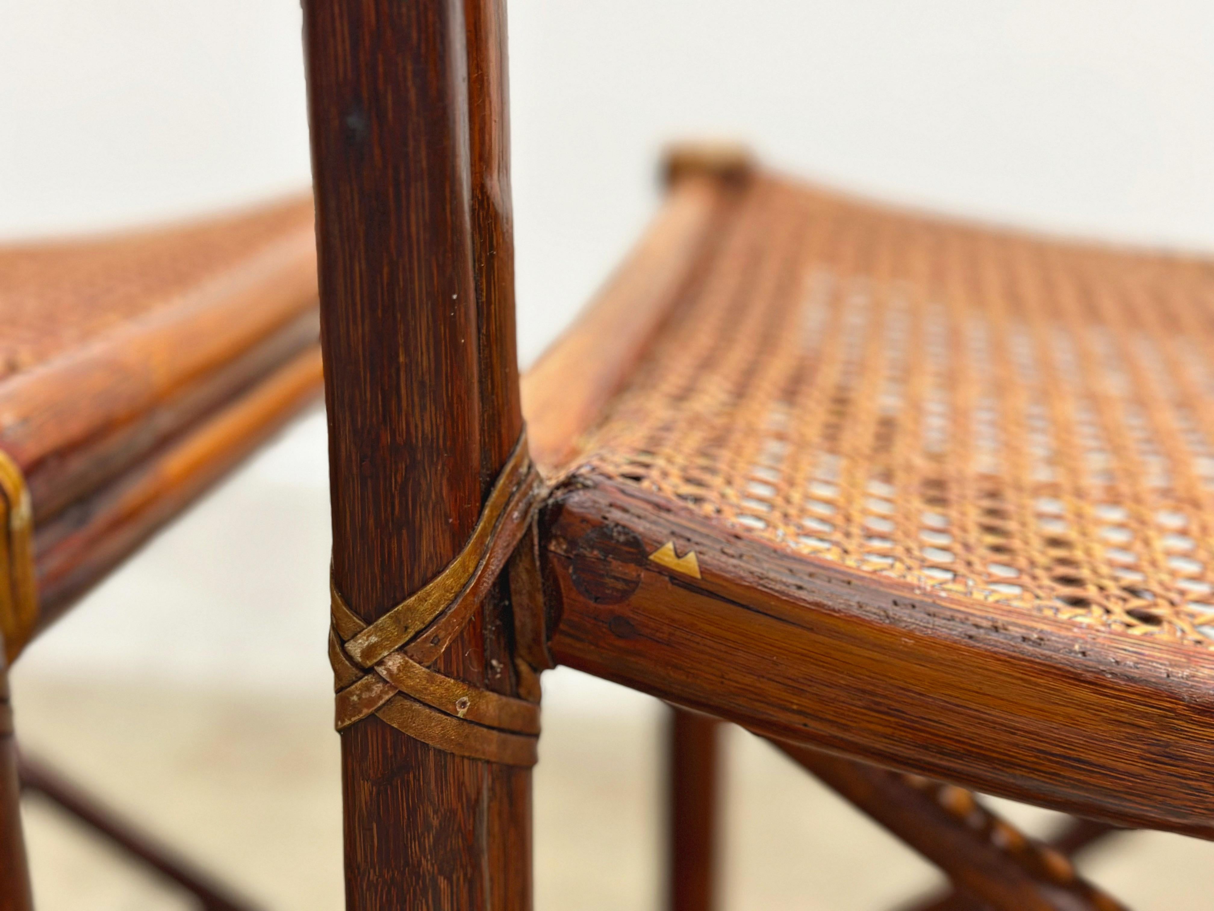 Paire de chaises de salle à manger vintage en rotin McGuire fabriquées dans le style moderne organique côtier californien. L'ensemble présente des cadres en rotin robuste dans un style chaise de directeur, avec des pieds droits reliés par des