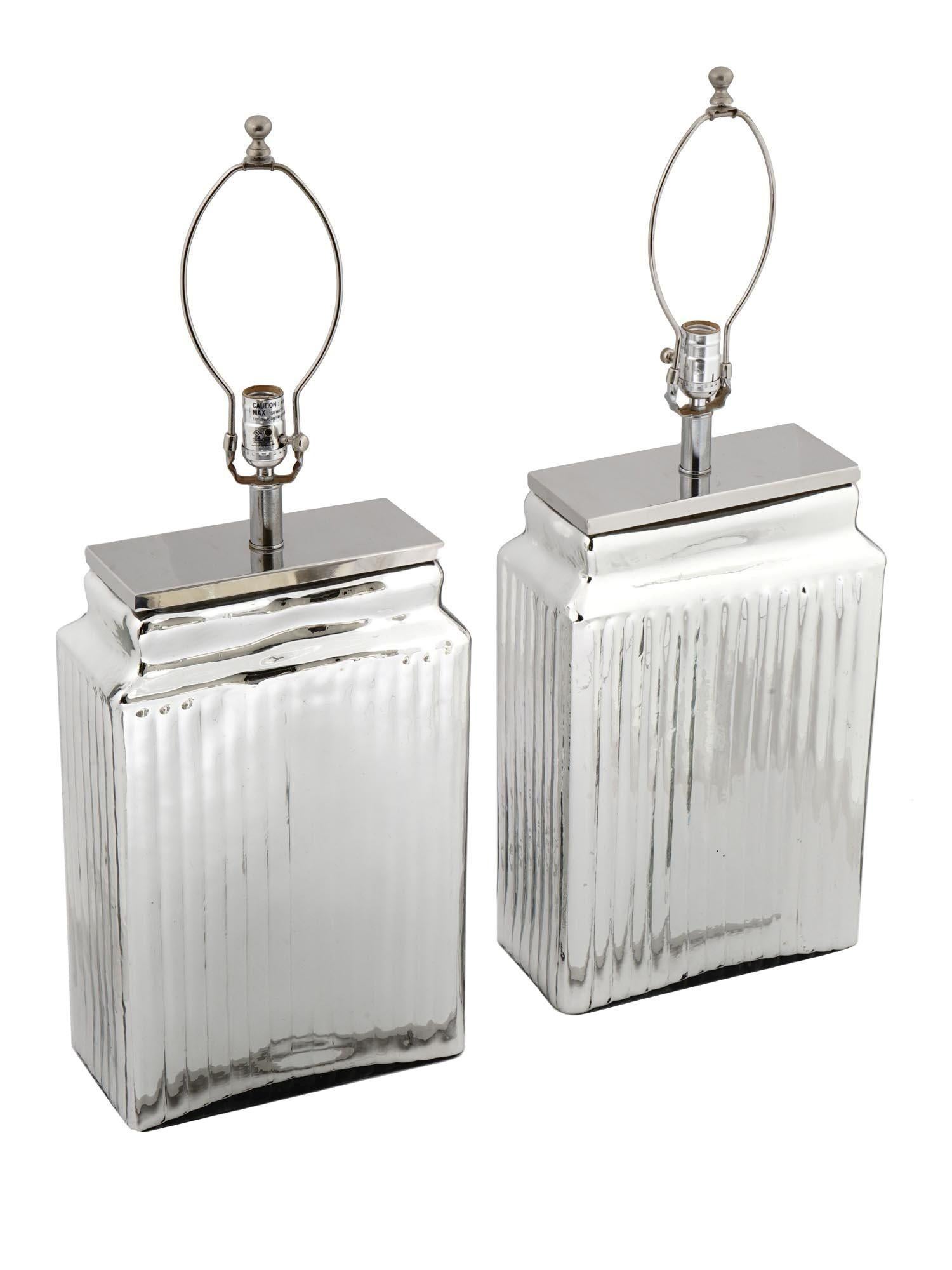 Pair of very large, impressive mercury glass table lamps of rectangular form with subtle ribbed sides and chrome plated hardware.  Fine working order and ready for use.